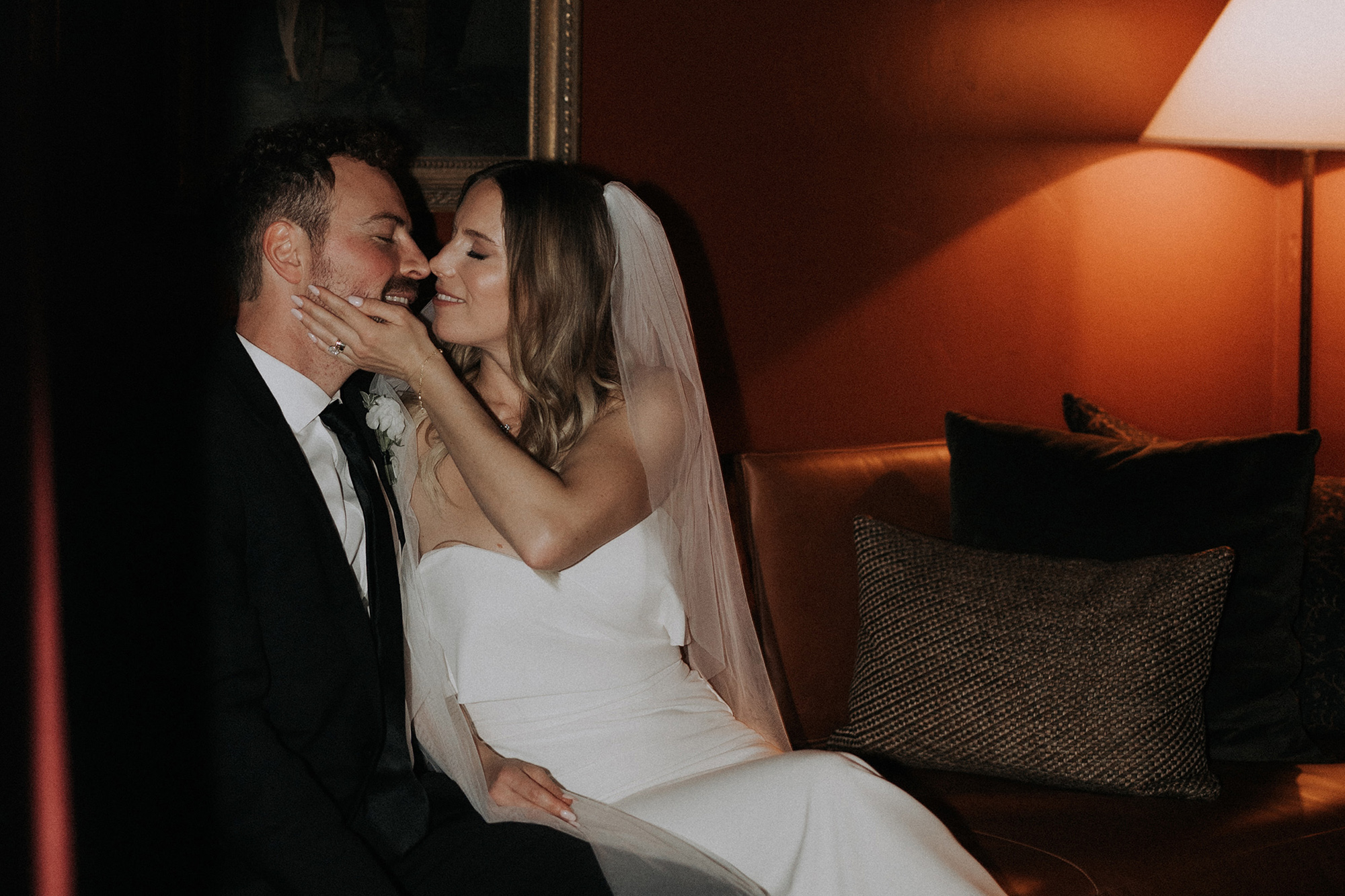 Bride and groom cuddling up under a low light in an intimate evening scene. Californian wedding.