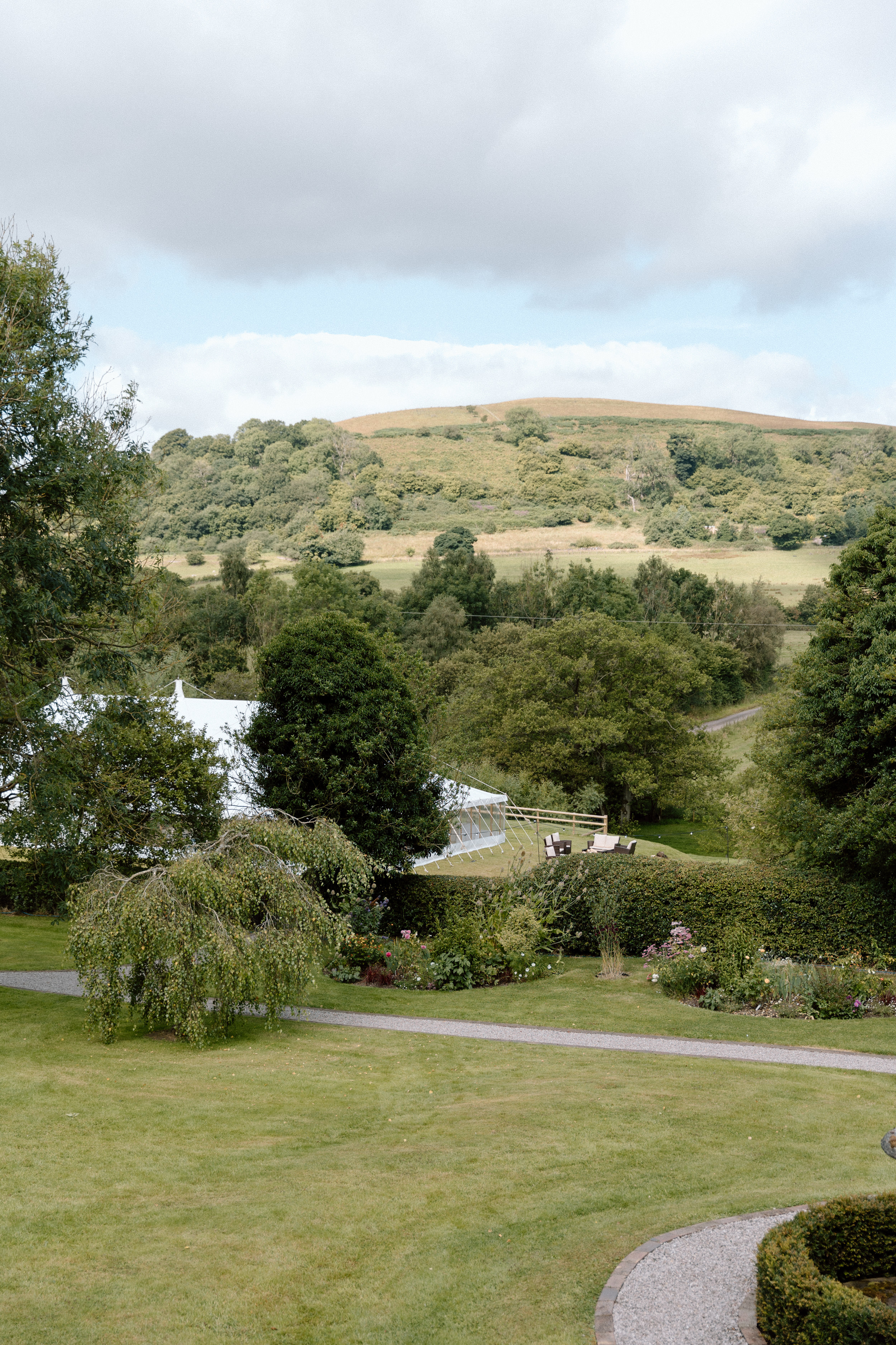Shropshire hills and countryside in the background of a marquee wedding at home.