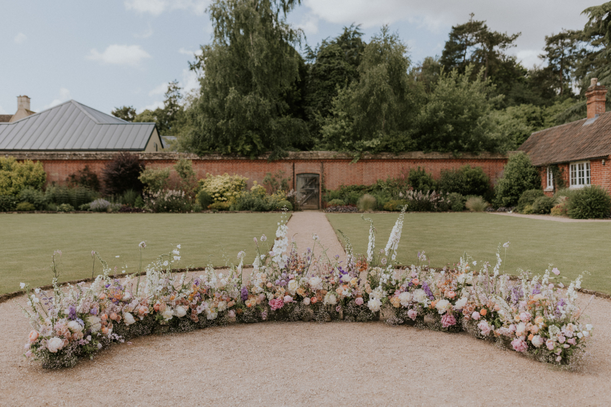 A Romantic Summer Wedding at Kin House in Wiltshire 23 Curved arrangement of meadow style flowers for an outdoor wedding reception at Kin House in Wiltshire. Flowers by Vervain Floral Design. Maja Tsolo Photography.