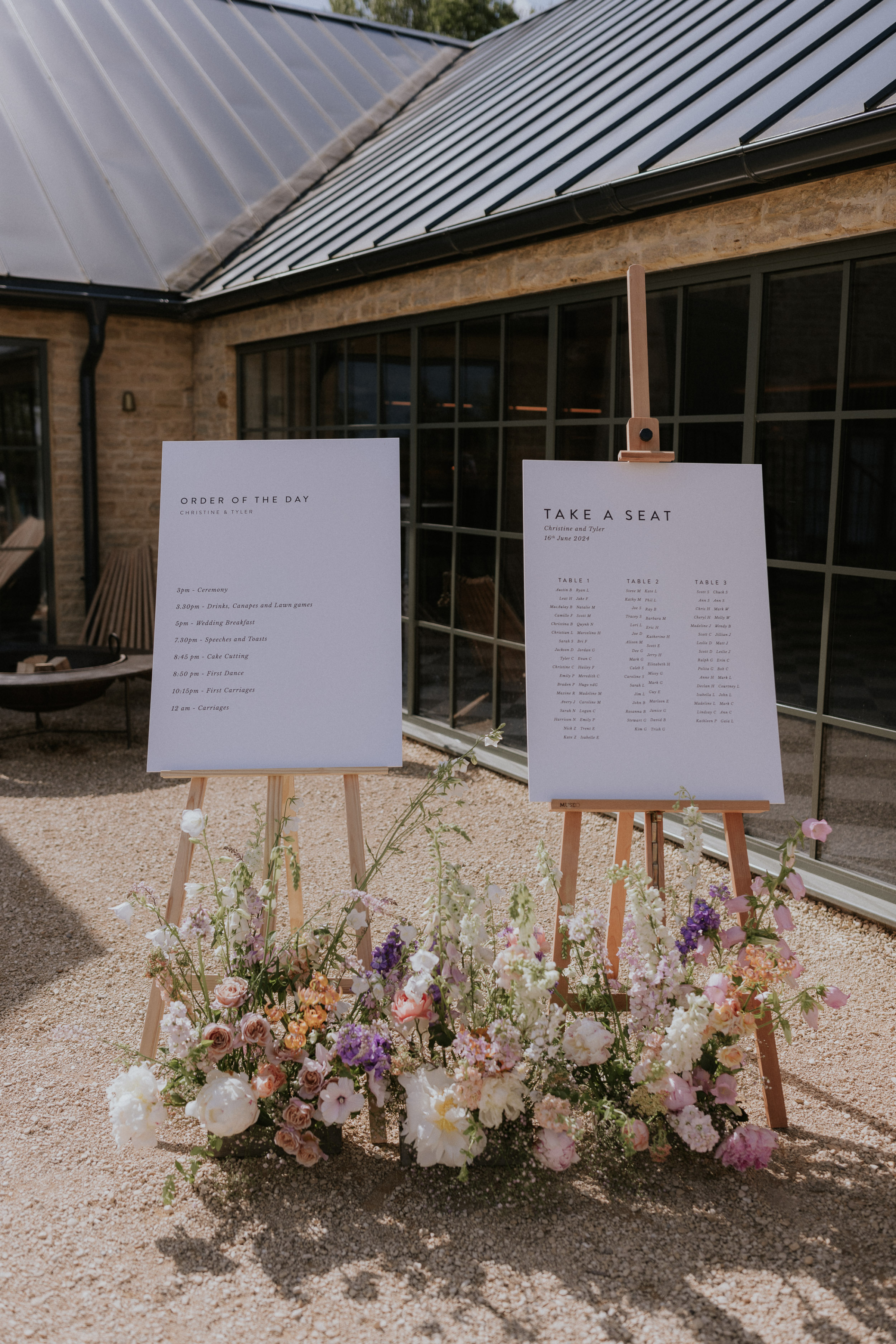 Wedding signs on easels at Kin House in Wiltshire. At the base of each easel are meadow inspired 