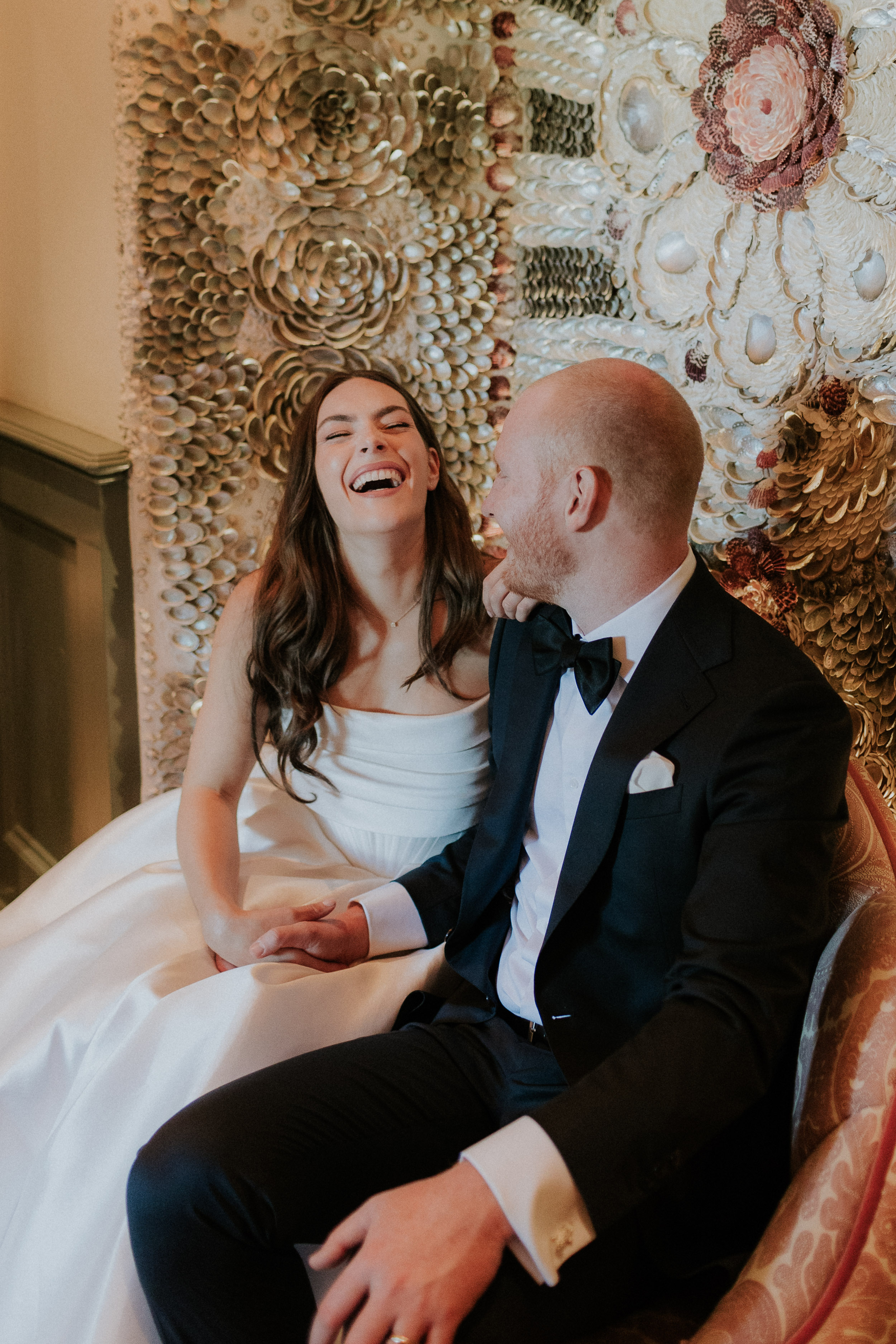Bride and groom laughing whilst seated. Maja Tsolo Photography.