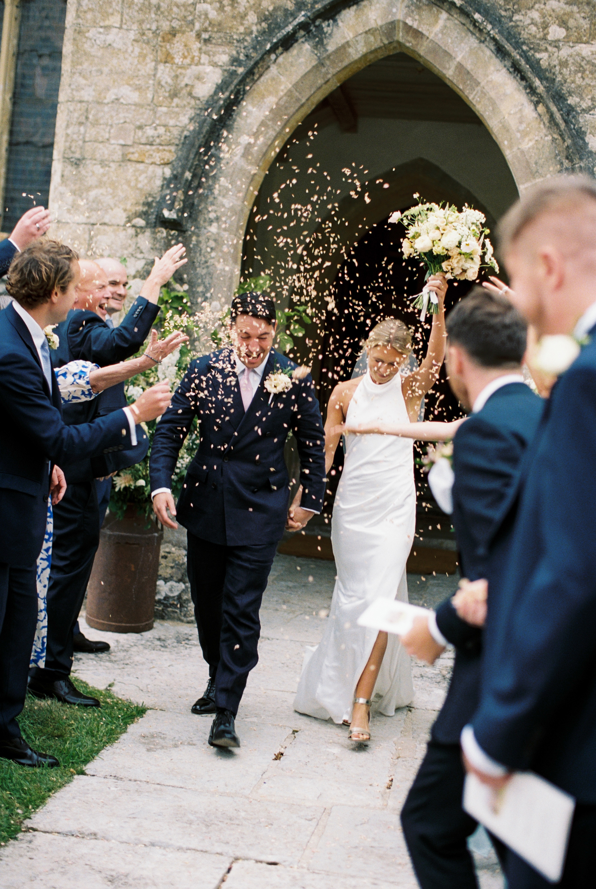 Bride and groom exiting the church wedding ceremony to a shower of confetti.