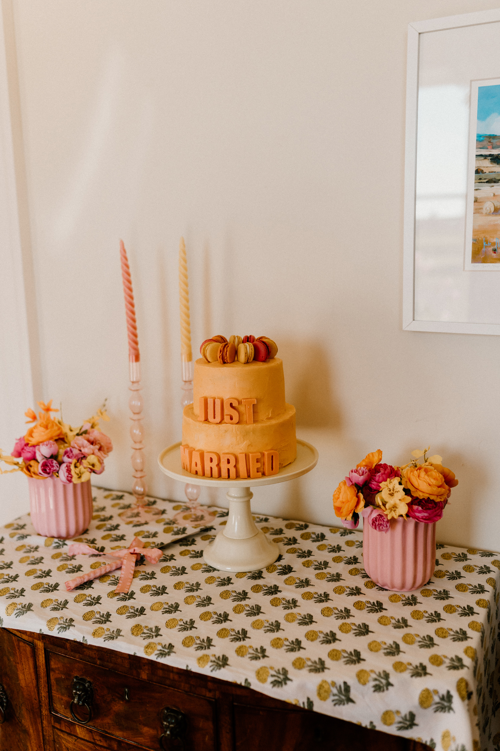 Hannah in Jesus Peiro for her Intimate Brunton House Wedding in Northumberland 41 Orange 2 tier wedding cake with JUST MARRIED lettering, topped with macarons.