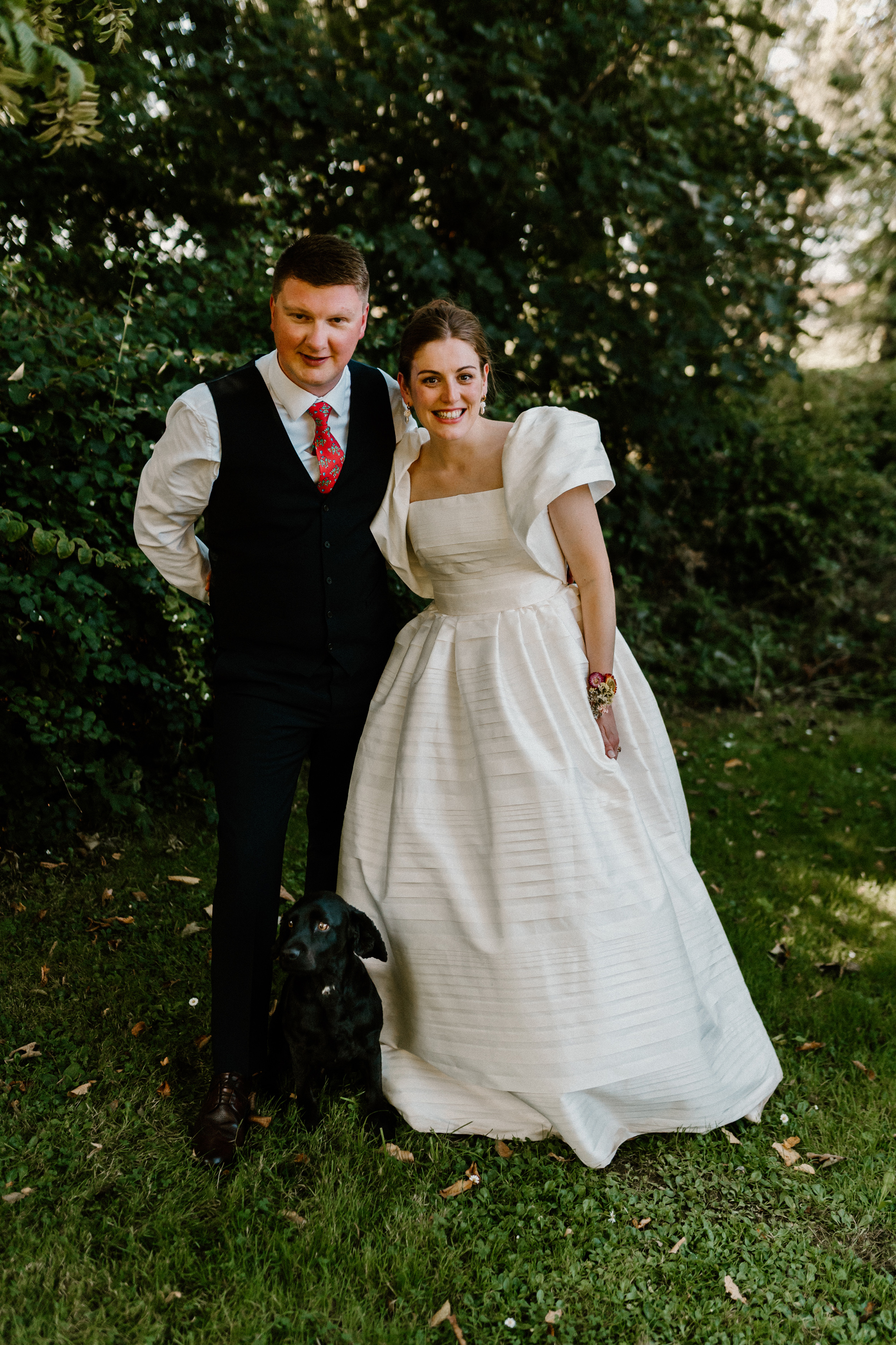Hannah in Jesus Peiro for her Intimate Brunton House Wedding in Northumberland 8 Bride wearing a puff sleeved, textured Jesus Peiro wedding dress and groom in a black waistcoat - a black dog by their side.