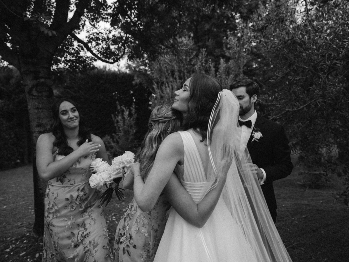An Elegant Destination Wedding in Cortona, Italy, with a Peter Langner Gown 34 Bride in a Peter Langner wedding dress embracing her bridesmaids after. the ceremony.