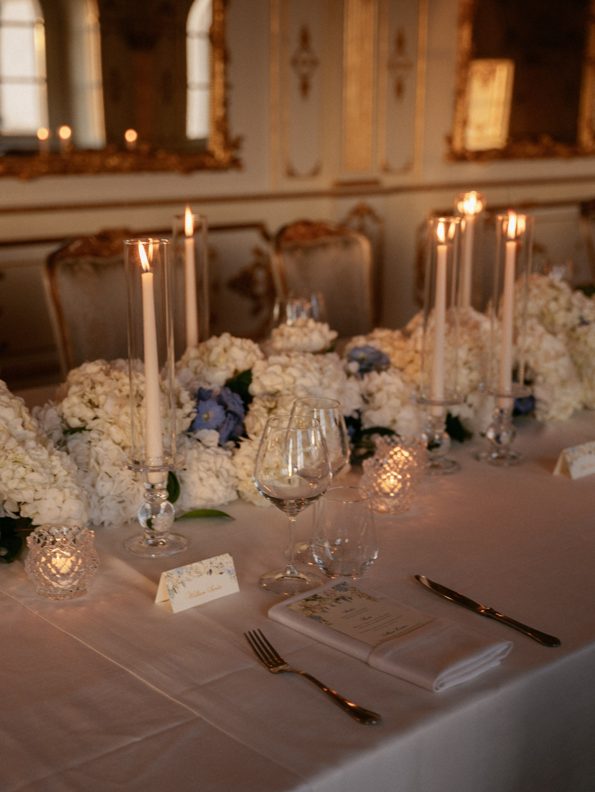An Elegant Destination Wedding in Cortona, Italy, with a Peter Langner Gown 38 Close up shot of a romantic Italian wedding reception table setting with taper candles, cream and blue hydrangea and floral stationery.