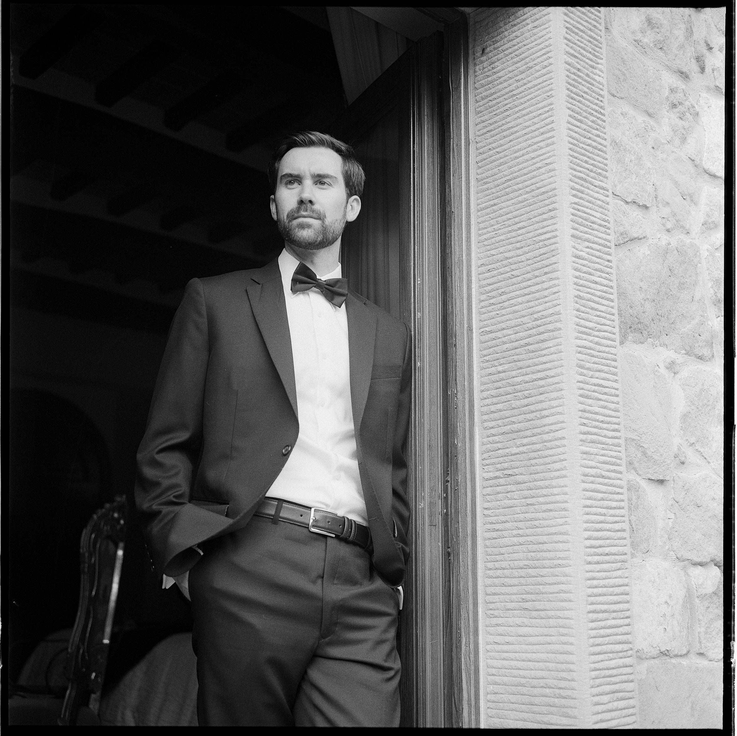 An Elegant Destination Wedding in Cortona, Italy, with a Peter Langner Gown 36 35mm film format wedding photography of groom in black tie suit on his wedding day.
