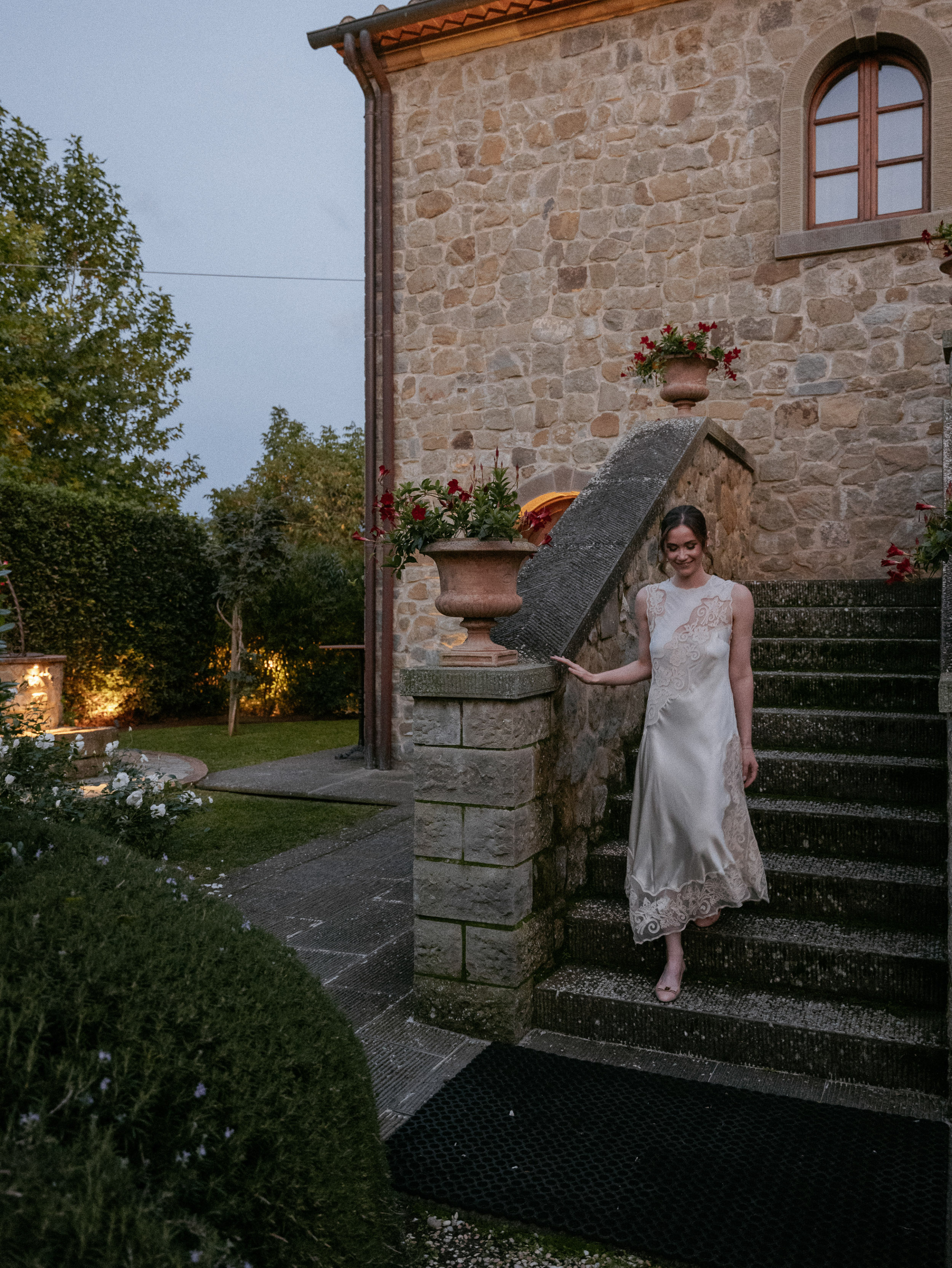 Bride in a lace dress for her rehearsal dinner at Relais La Corte Dei Papi wedding venue in Cortana, Italy.