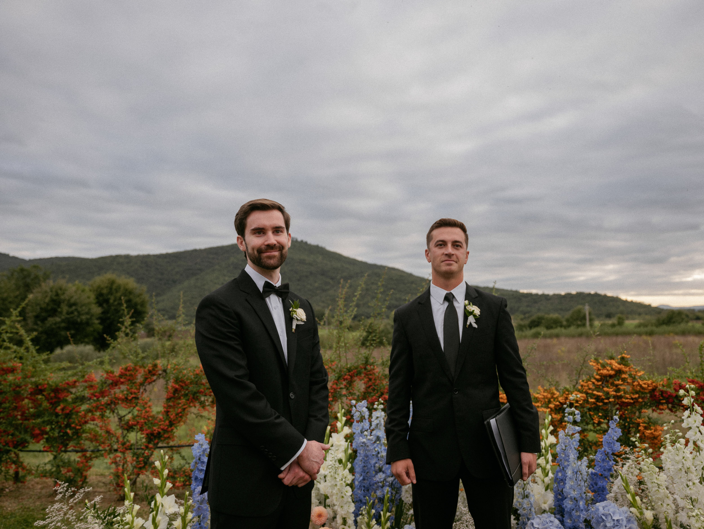 Groom waiting for his bride during their outdoor Italian wedding ceremony at  Relais La Corte Dei Papi in Cortona in Italy.