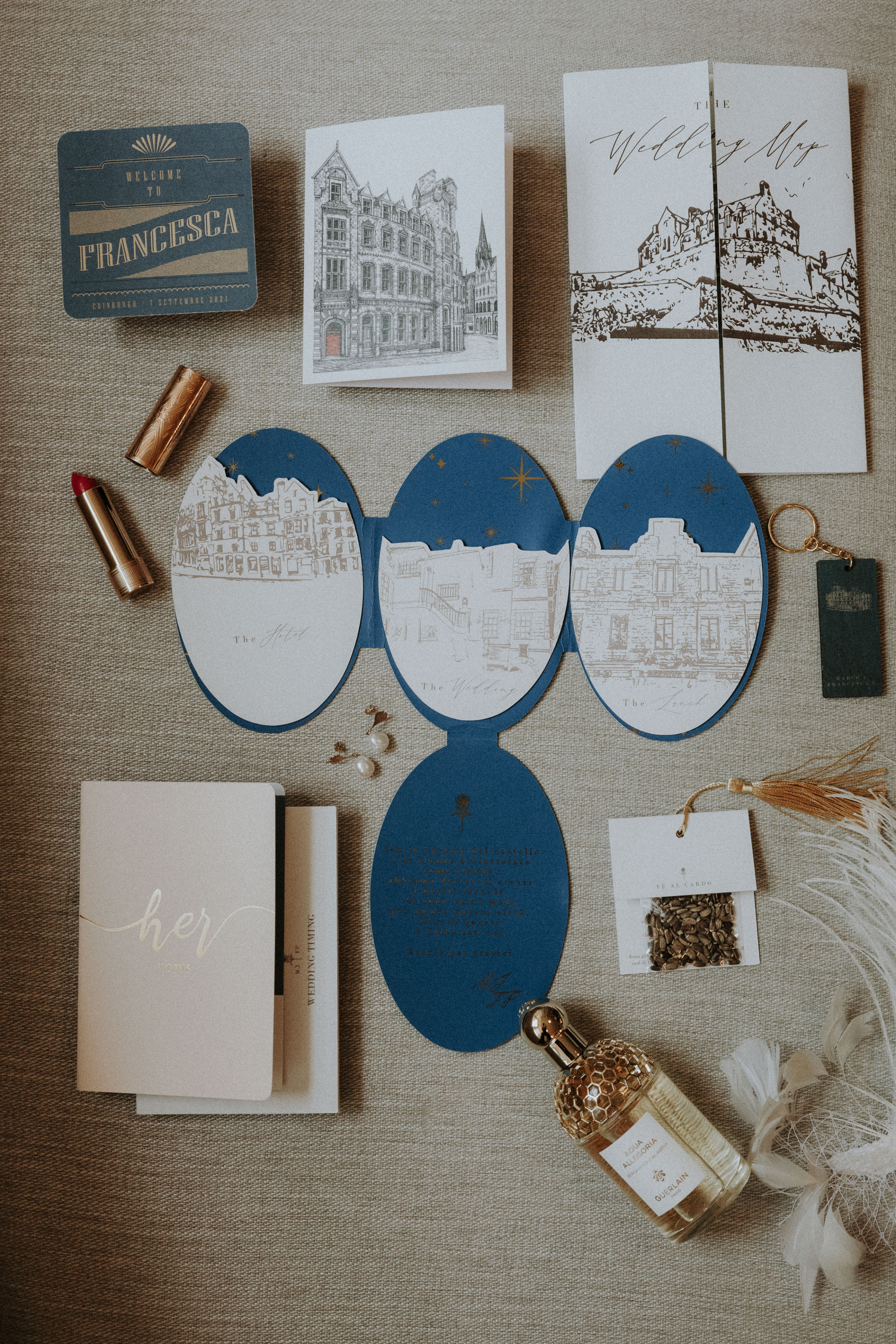 Flatlay of oval shaped wedding stationery in blue, depicting the city landscape of Edinburgh. Bernadeta Kupiec Photography.