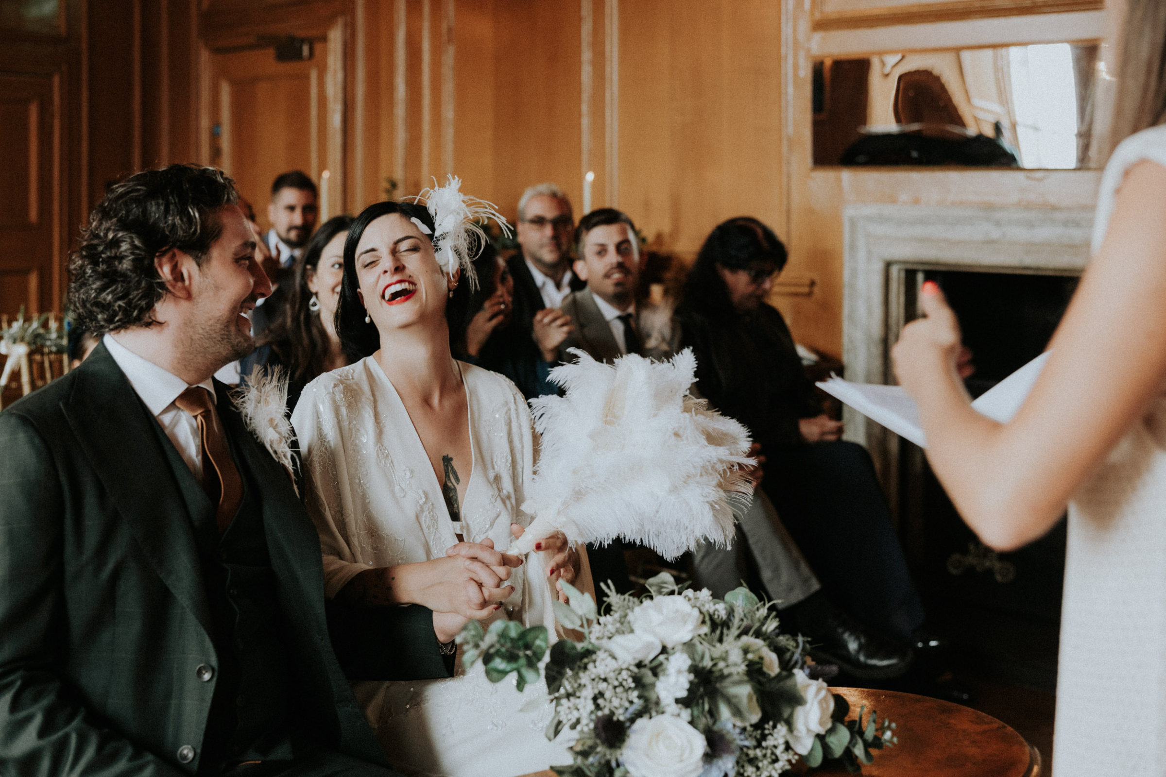Seated bride and groom laughing during their wedding ceremony at Riddles Court in Edinburgh. Bernadeta Kupiec Photography.