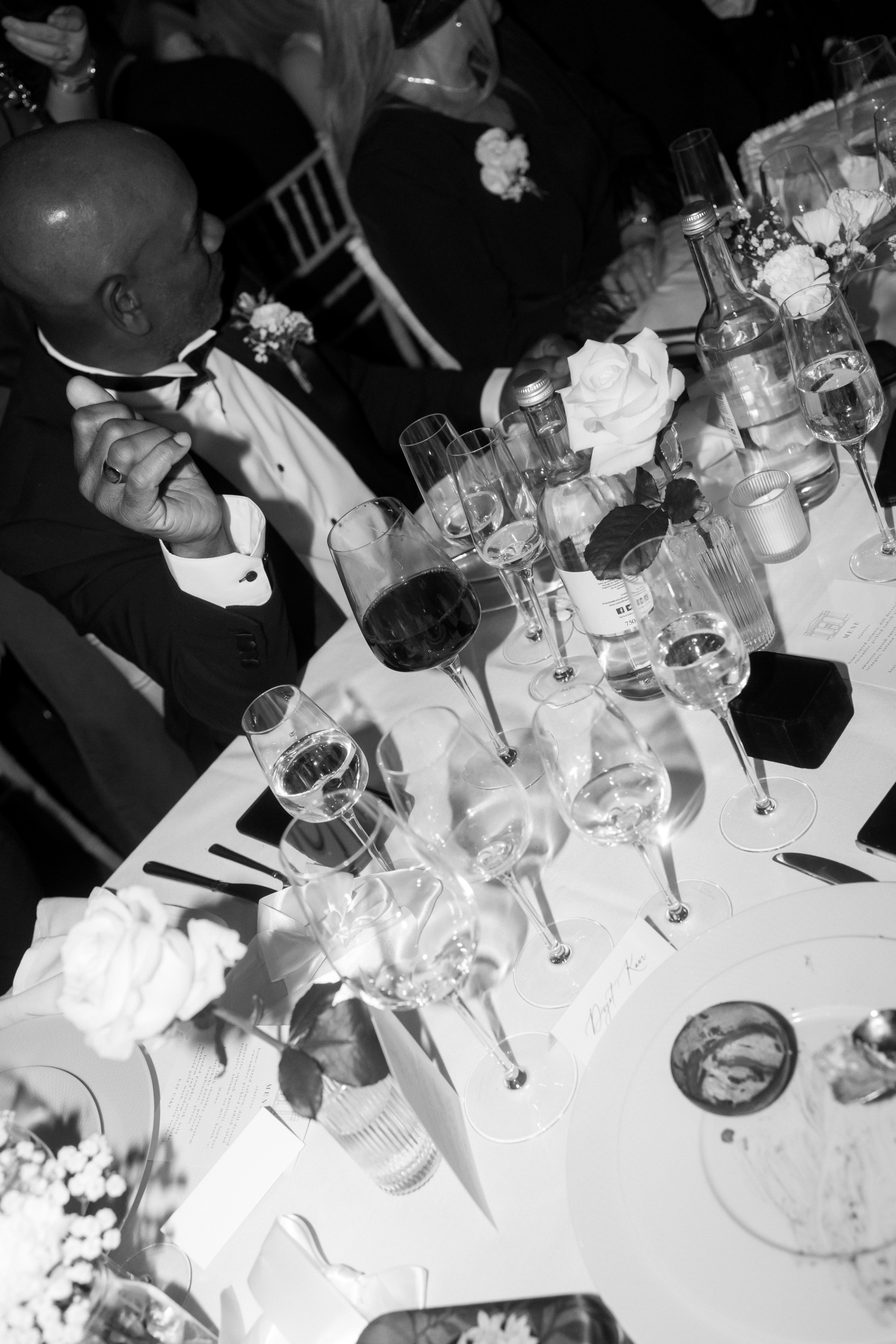 Guests raise glasses in celebration during the reception, surrounded by floral centrepieces, candlelight and elegant glassware at the wedding table.