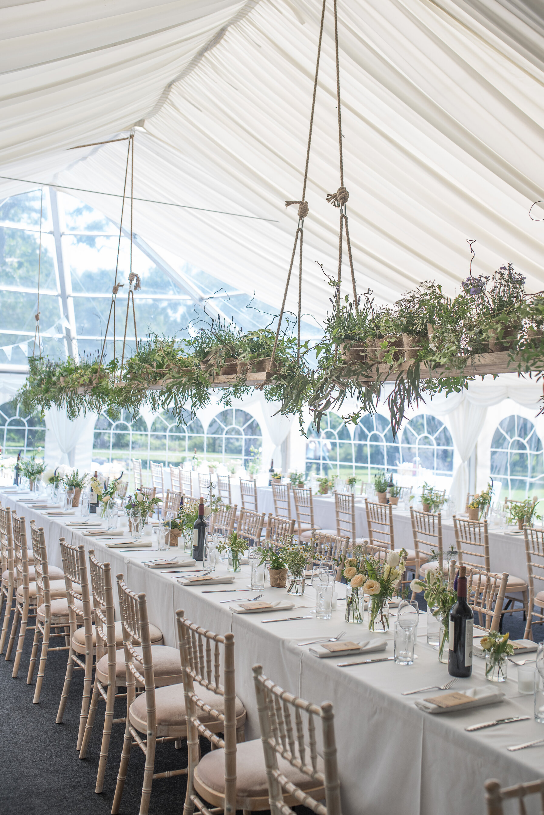 Elegant hanging greenery hanging inside a wedding marquee - by Luvshifting Flowers, Hampshire wedding florist.