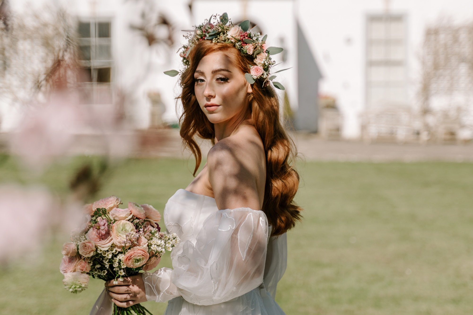 Pre-raphaelite bridal editorial. Bride wears flowers in her hair and a flowing tulle dress.