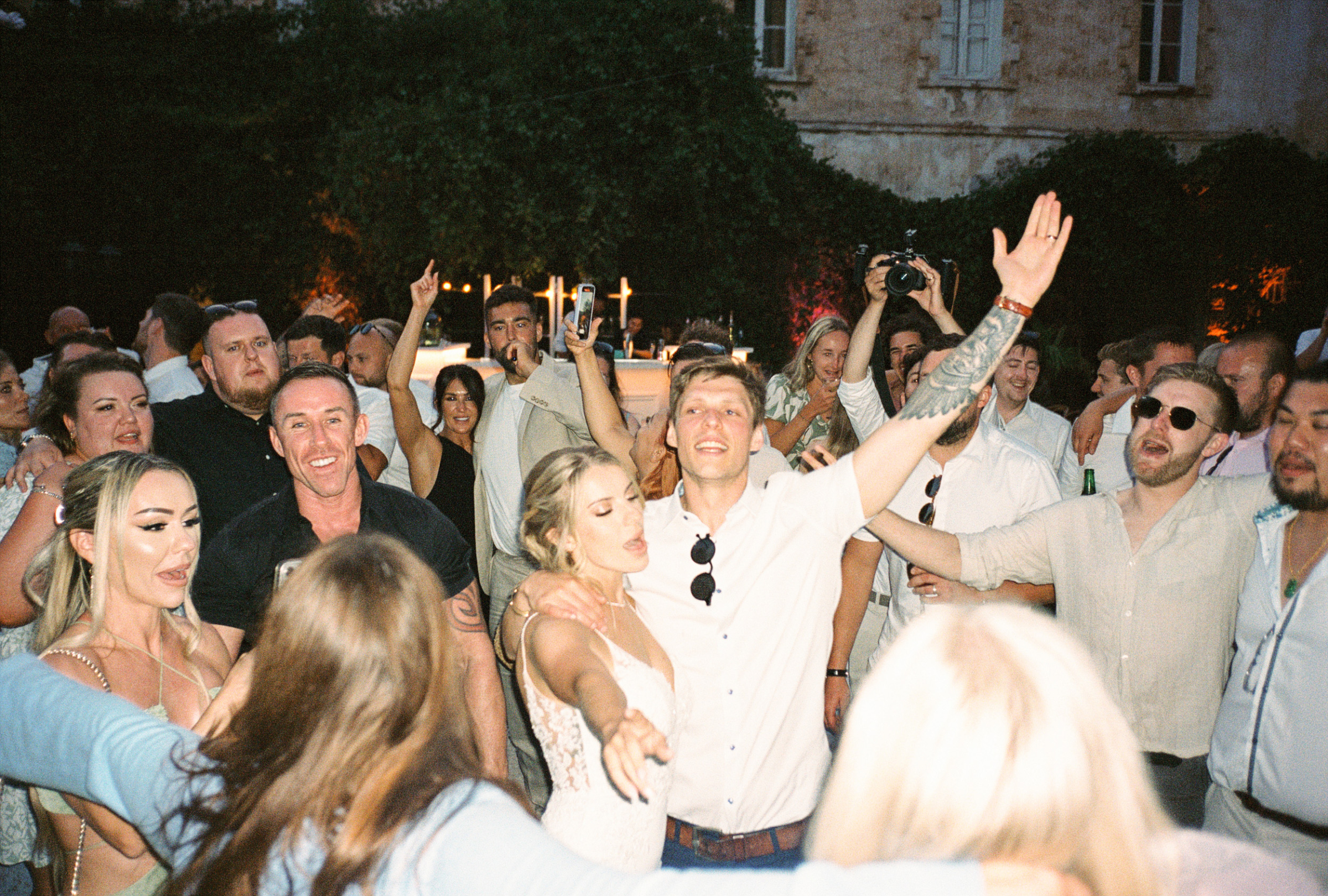 An Elegant Modern Wedding at Chateau de Robernier 89 Bride, groom and their wedding guests dancing at night at night at Chateau de Robernier in Provence, South of France.