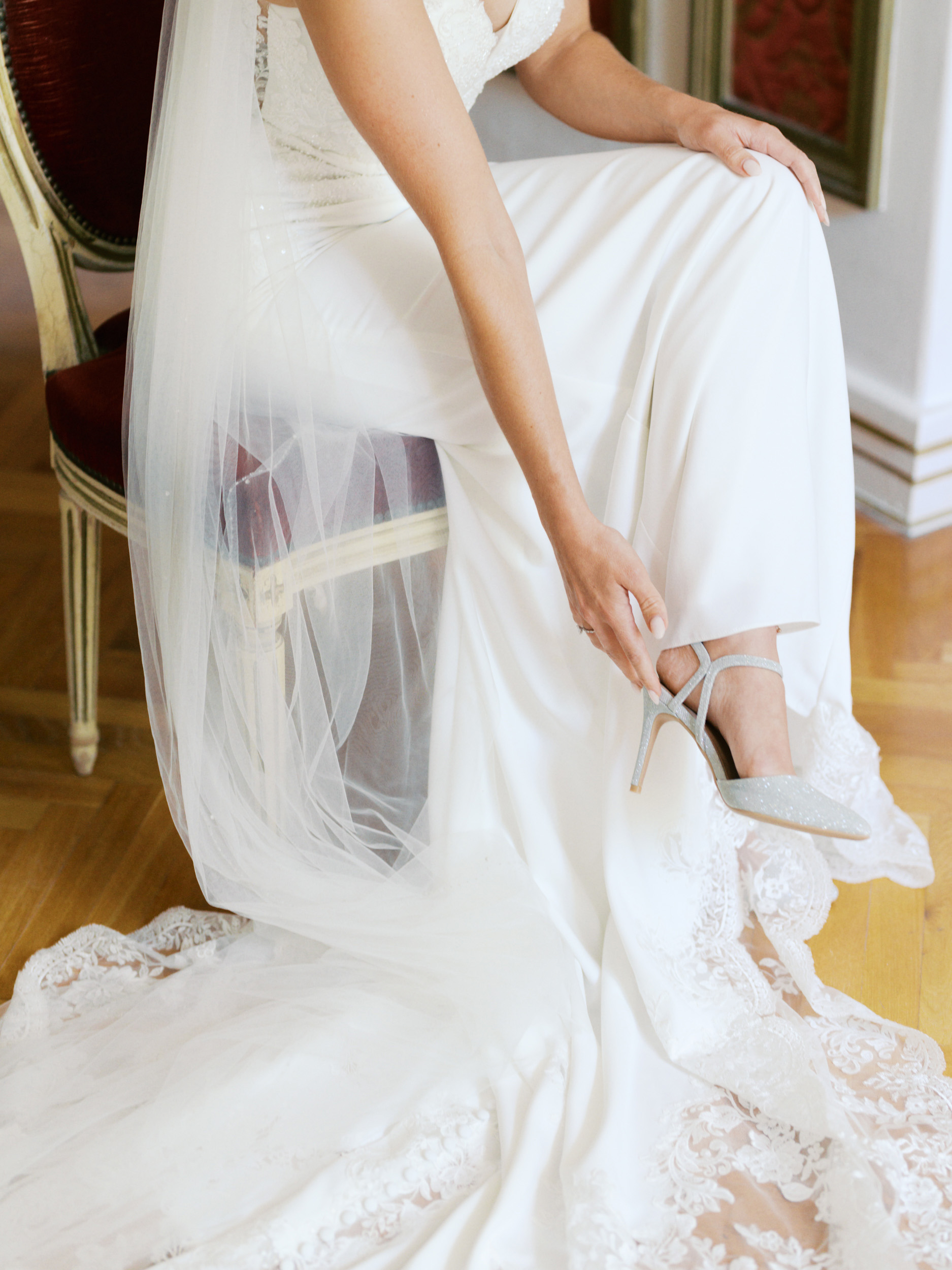 An Elegant Modern Wedding at Chateau de Robernier 58 Close up shot of bride putting sparkly shoes on whilst seated.