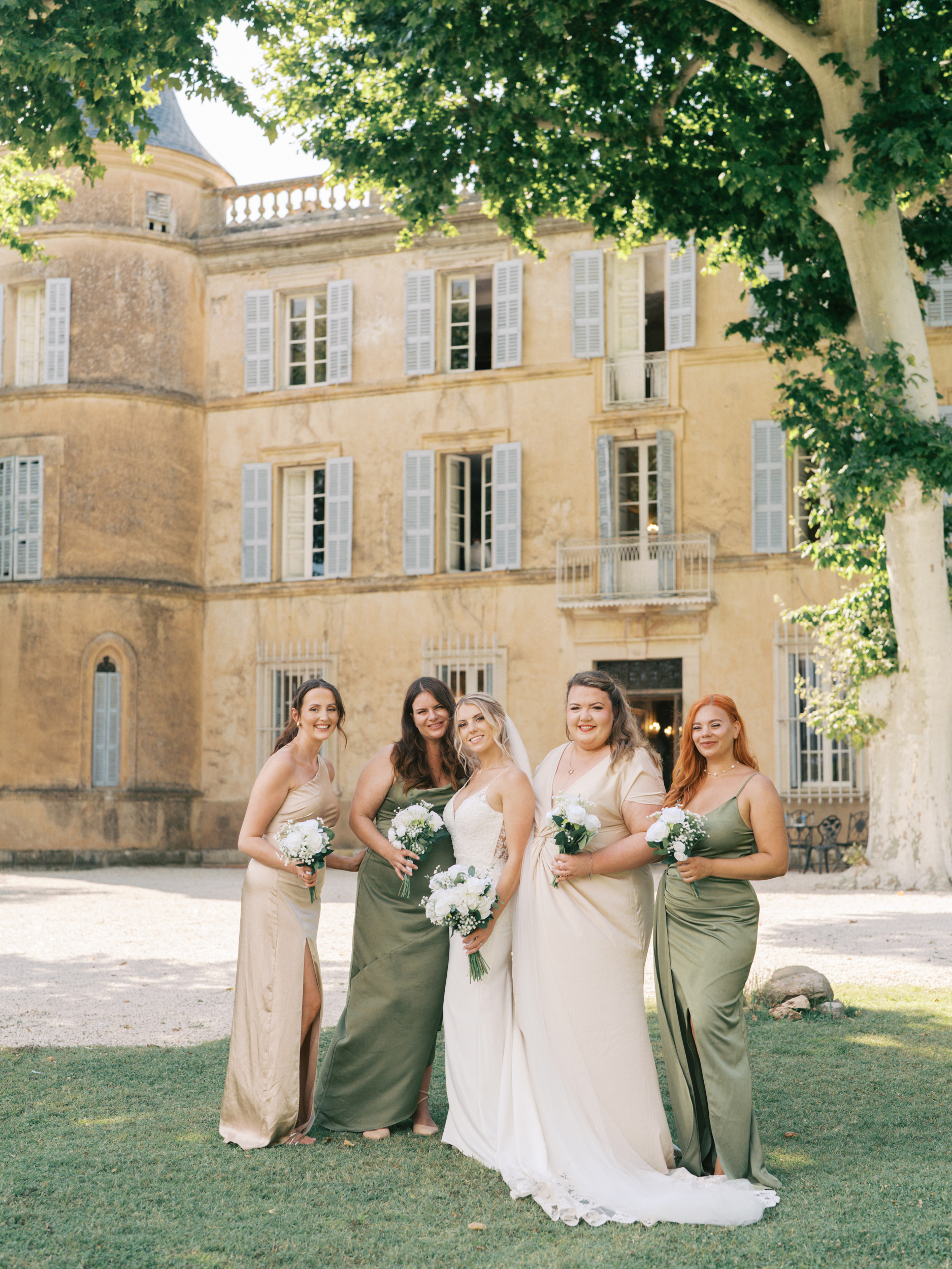 An Elegant Modern Wedding at Chateau de Robernier 61 Bride and bridesmaids in green and champagne dresses outside Chateau de Robernier in Provence, South of France.