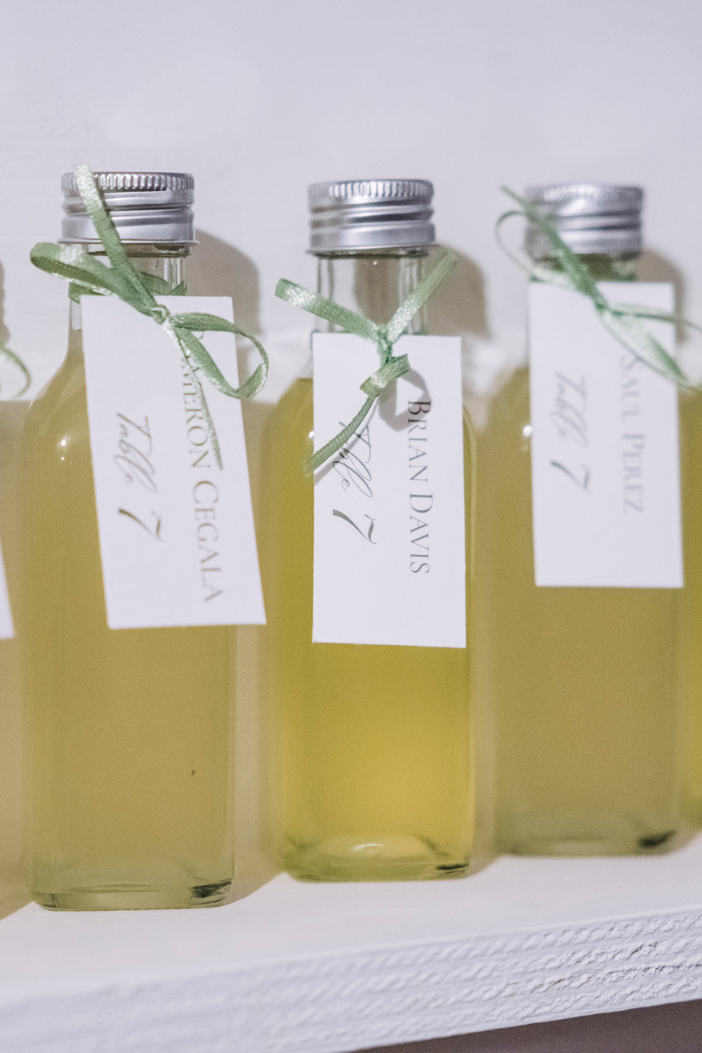 Miniature bottles of limoncello used as escort card at a wedding.