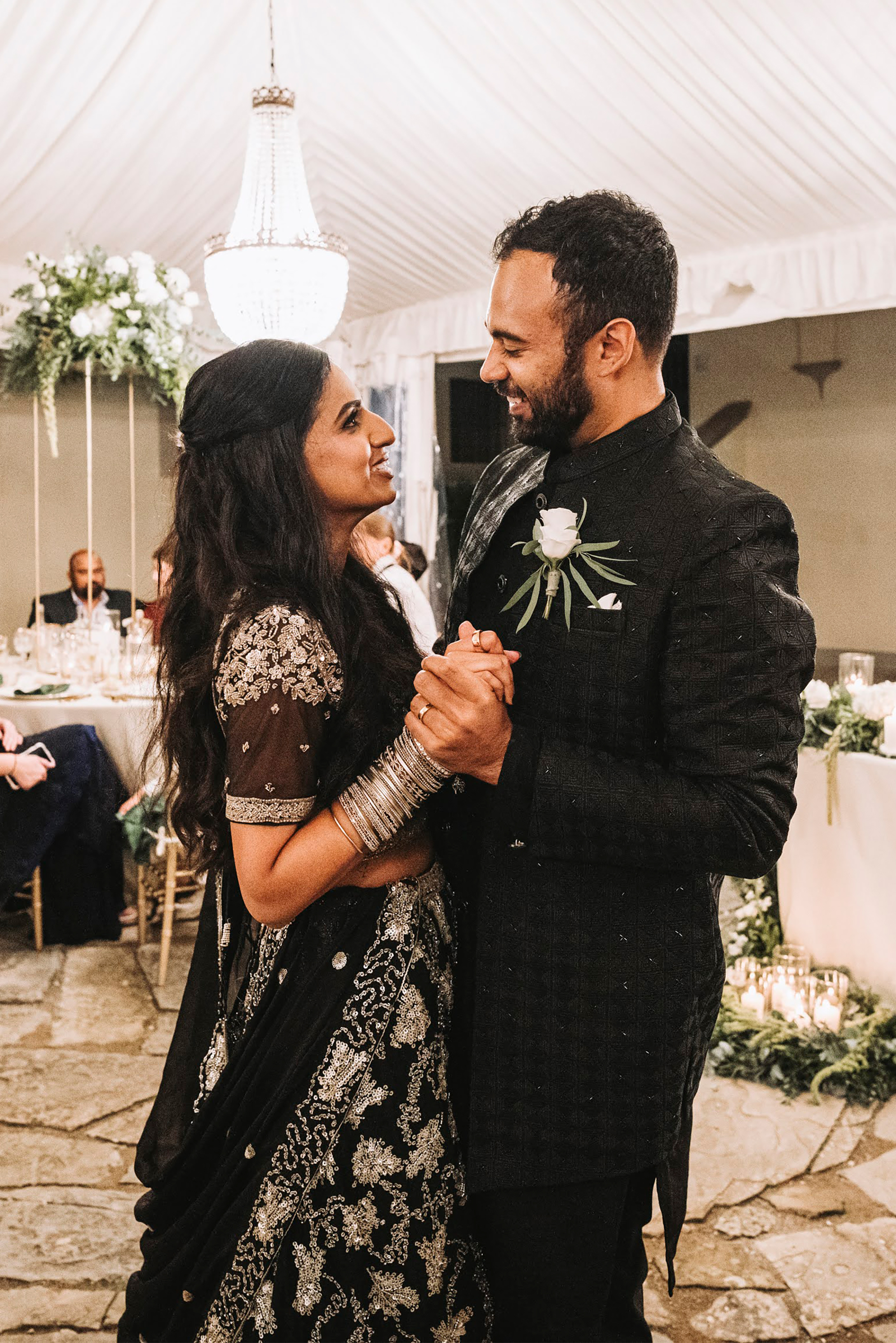 An Elegant Fusion of Indian Tradition and Italian Beauty 93 Modern Indian bride and groom wearing modern black attire. Teh bride wears multiple bangles and black sequinned traditional Indian dress.