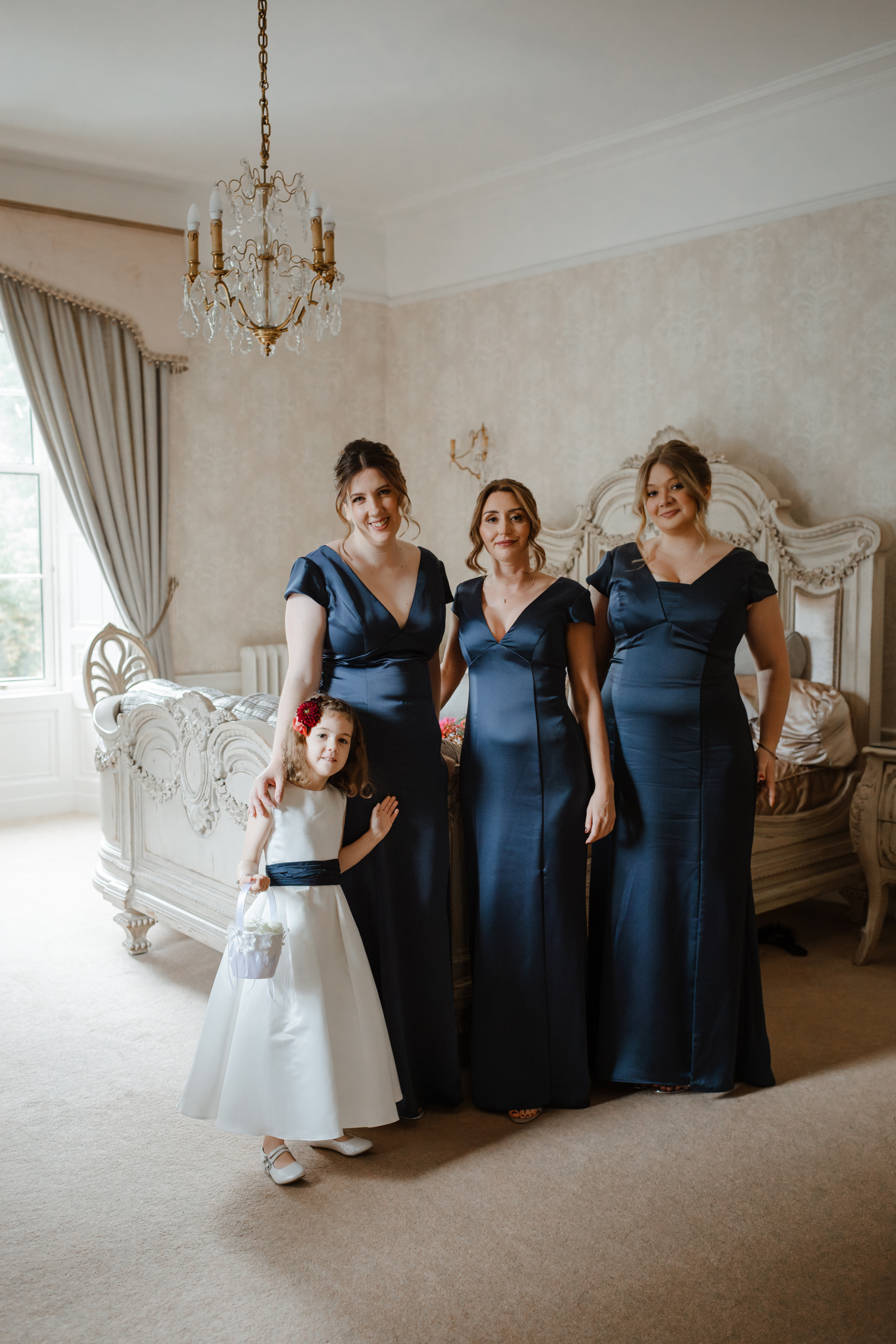 Savannah Miller Elegance for a Joyful Autumn Wedding at Drumtochty Castle 68 Bridesmaids in navy blue dresses and a flowergirl in a white dress with a navy blue sash.