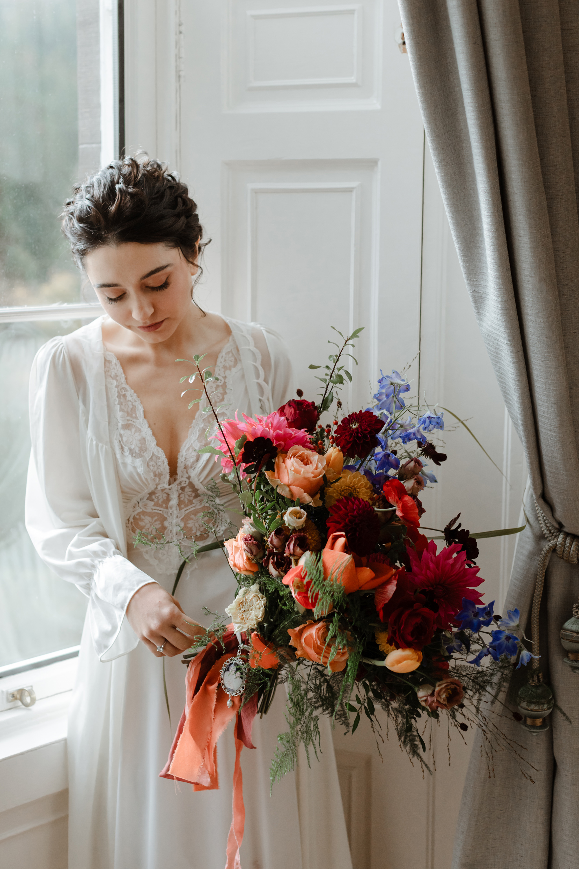 Savannah Miller Elegance for a Joyful Autumn Wedding at Drumtochty Castle 65 Bride in a vintage 1970's Olga body suit, carrying a huge colourful bridal bouquet with peach silk ribbons.