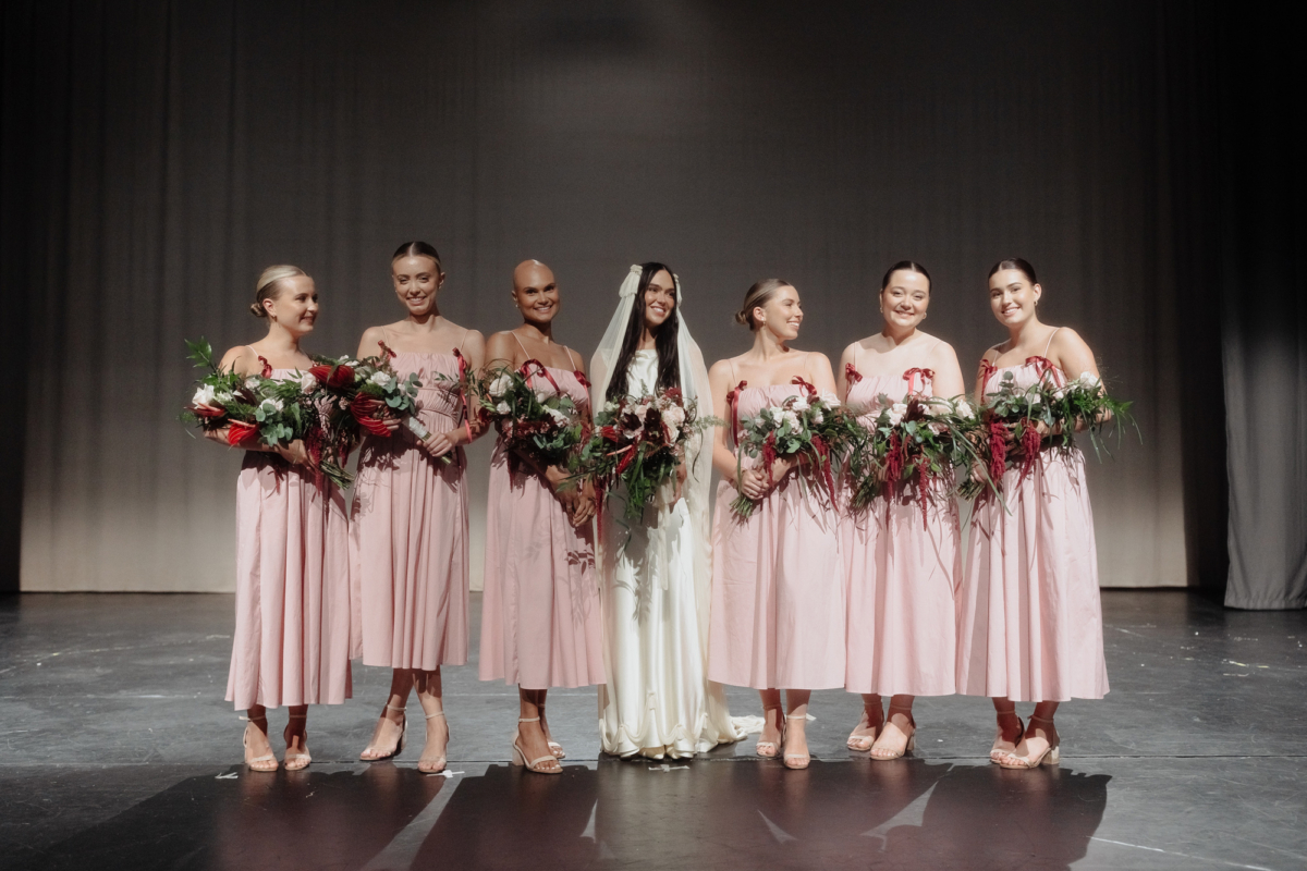 Bridesmaids in pink dresses from COS with red tassels. Bride wears a Paula Nanda 