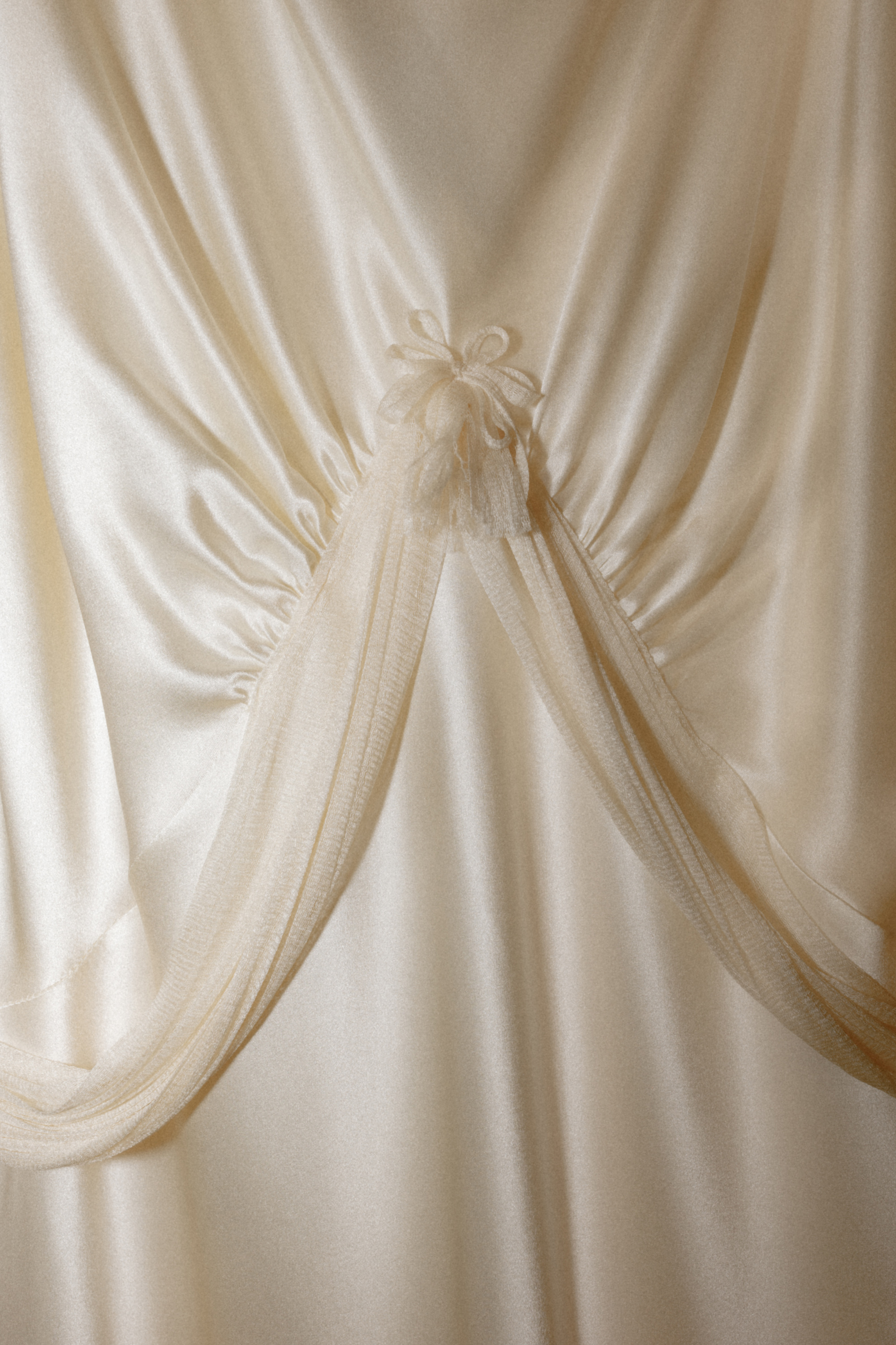 Close up shot of a Paula Nanda wedding dress with draped fabric detail.