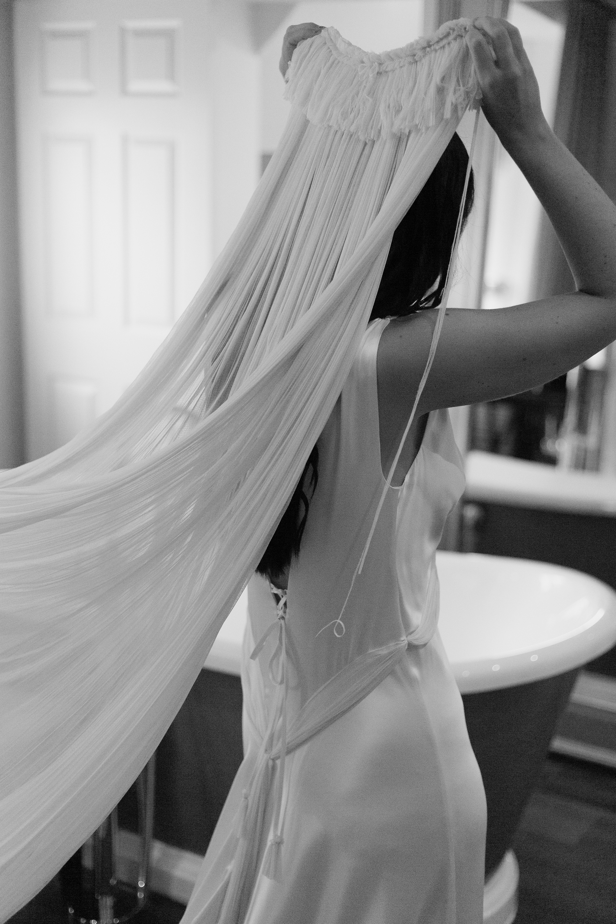 Bride putting on her fringed and tasseled Paula Nanda veil.