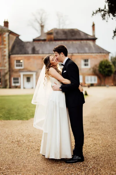 A bride and groom embrace during their wedding at Syrencot, Wiltshire.