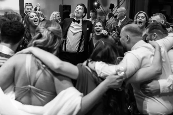 A groom sings with guests during his wedding