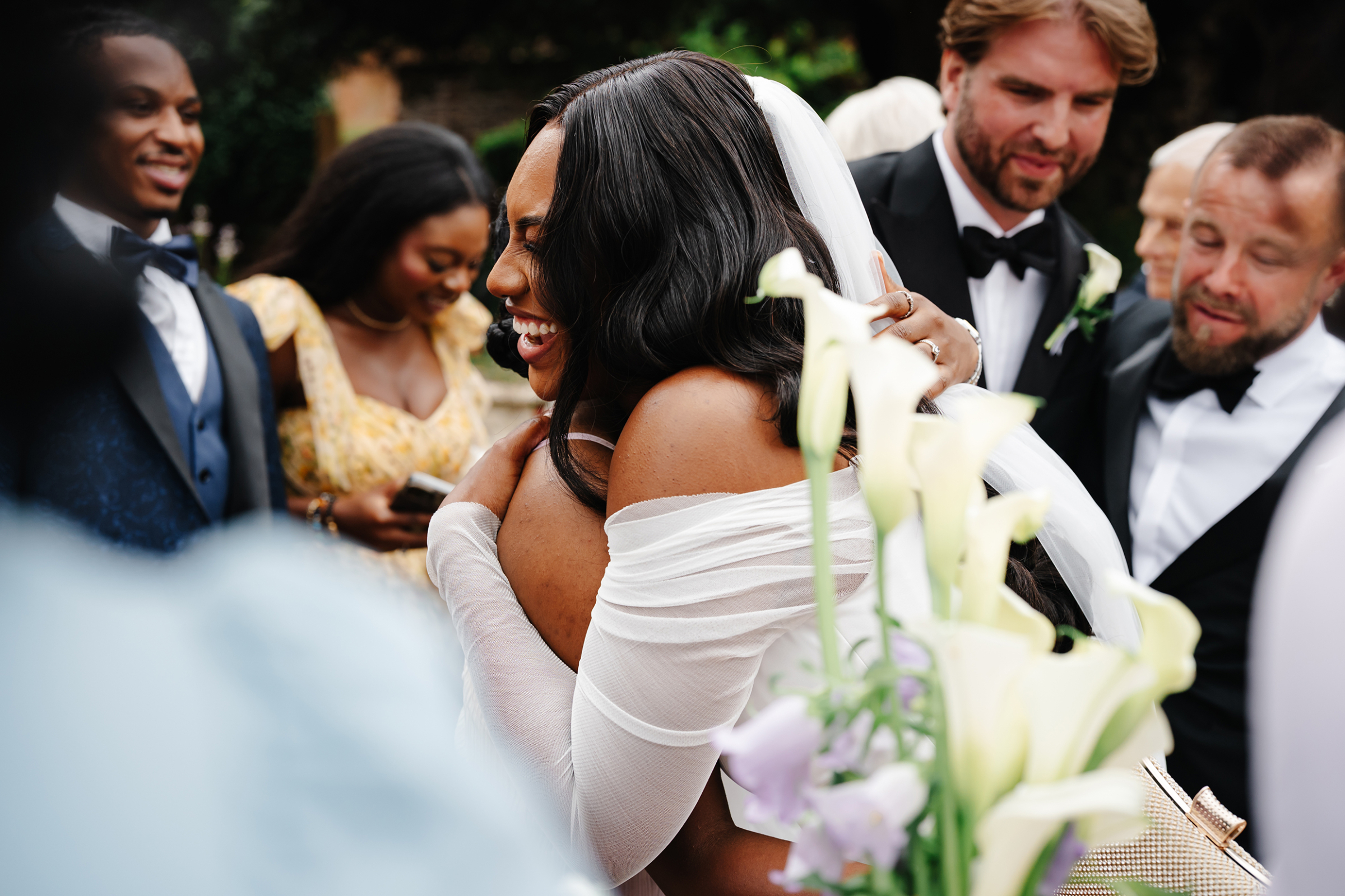 Black bride hugging a wedding guest tightly. 