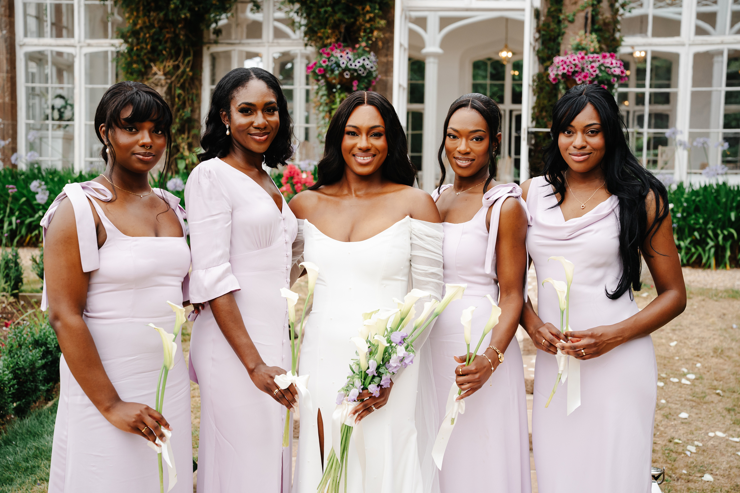 Radiant and elegant Black bride with her bridesmaids wearing lilac dresses by Maids To Measure. St Audries Park wedding venue,Somerset.