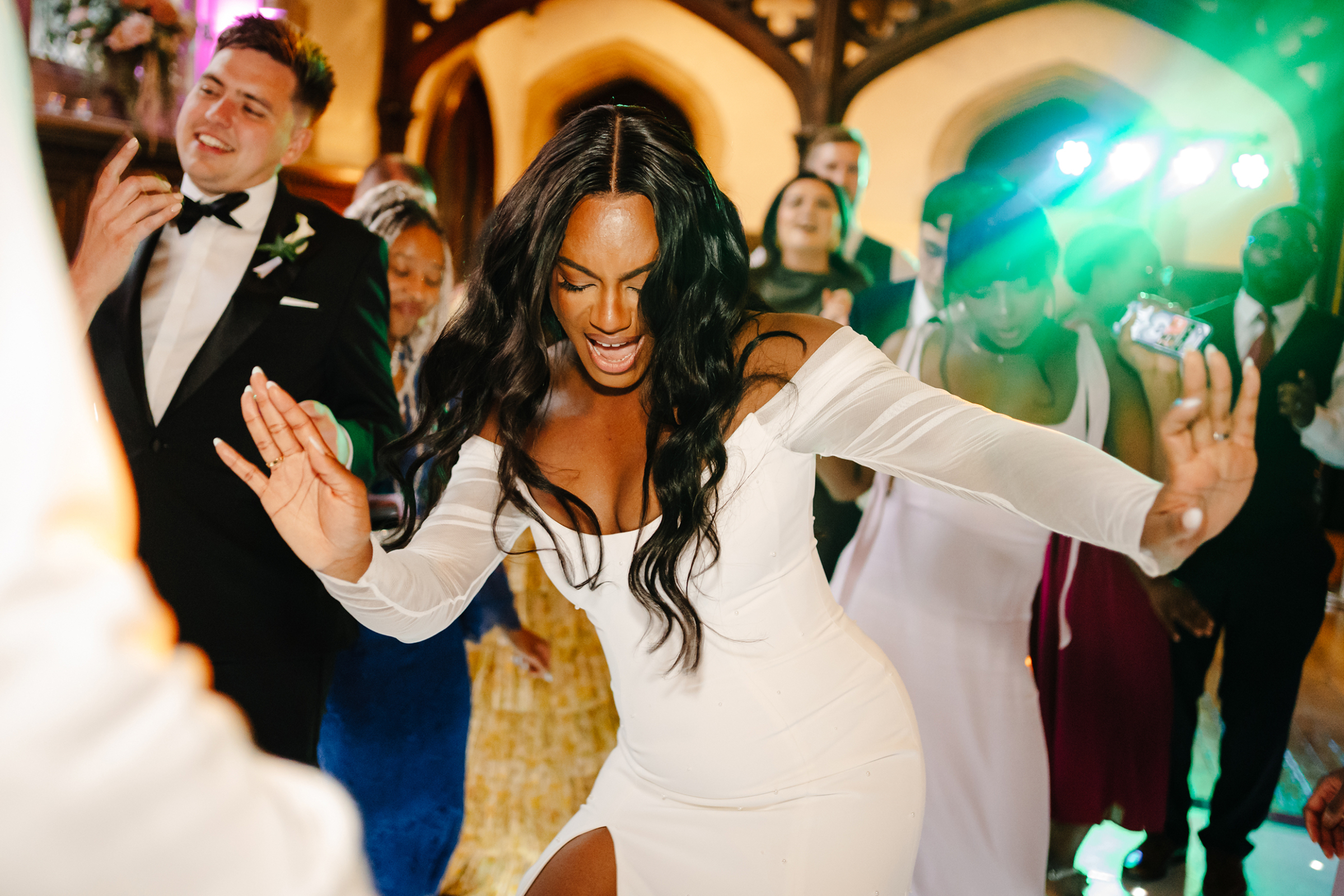 Black bride dancing with wild abandon on her wedding day. She wears a Sarah Seven dress. St Audries Park wedding.