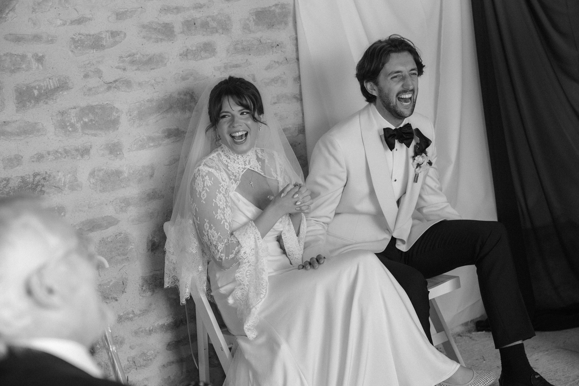 Real bride and groom sat back and laughing during their wedding ceremony.