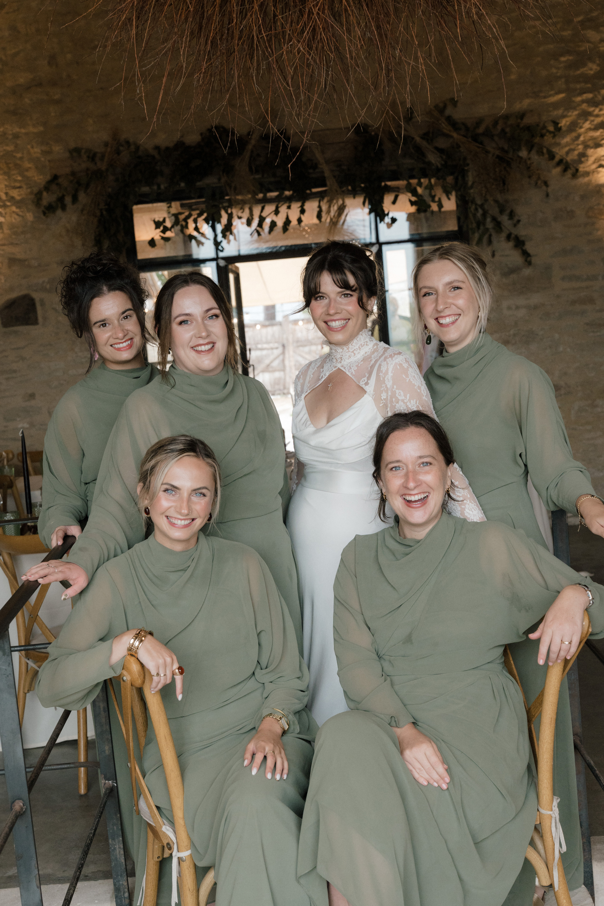 Bridesmaids in olive green long sleeved dresses at Gulliver's Hall, a Unique Home Stays wedding venue in The Cotswolds.