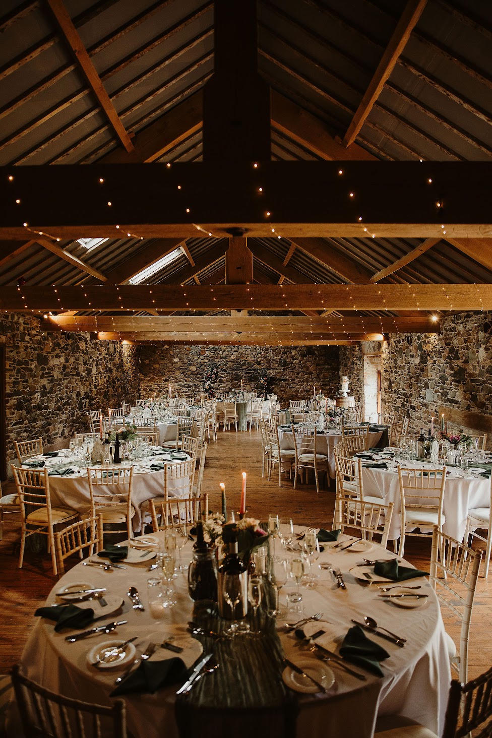 Round tables inside the Lovable Barn at Low Hall The Lakes - a beautiful and rustic Lake District wedding venue.