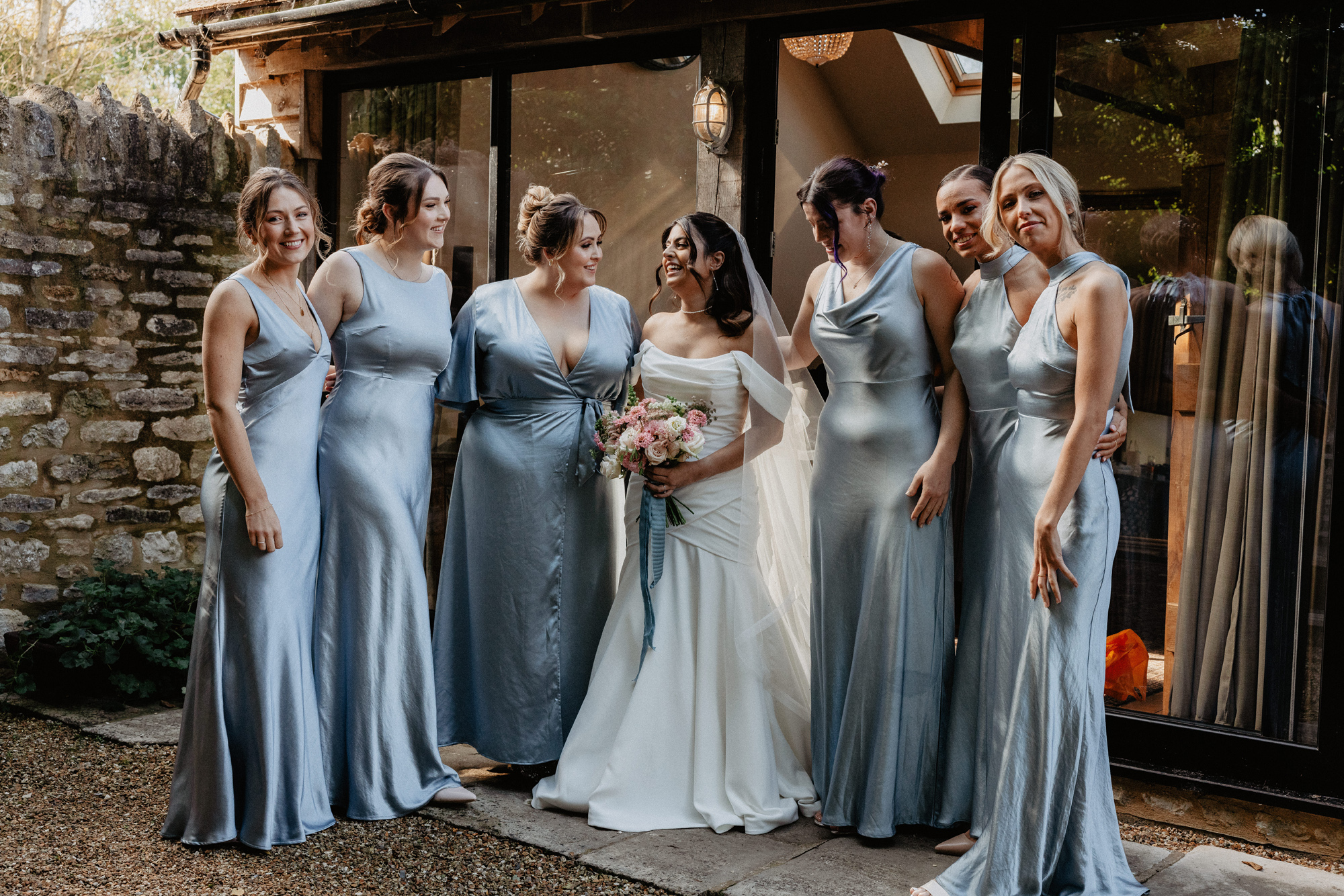 Tythe barn wedding, Oxfordshire, bride wears JS Couture, and her bridesmaids were Six Stories in ice blue.