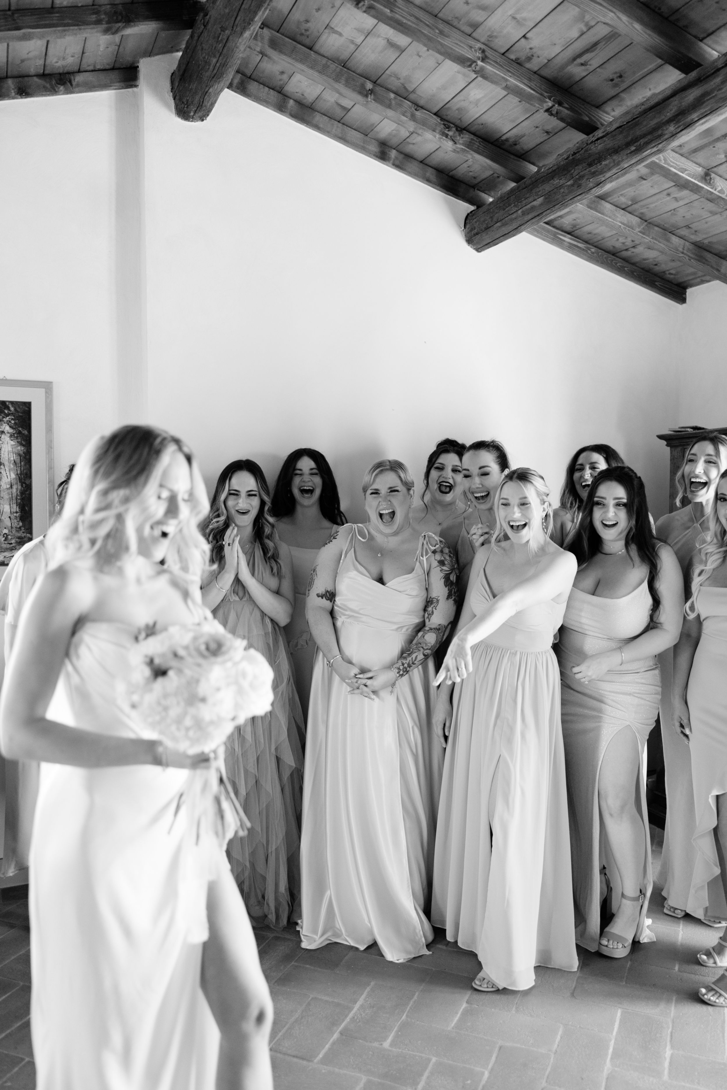 Wedding Borgo Sant Ambrogio Tuscany Italy 44 - A Modern, Romantic Destination Wedding at Borgo Sant Ambrogio in Tuscany Bridesmaids giggling gleefully as the bride flashes a leg from her wedding dress.
