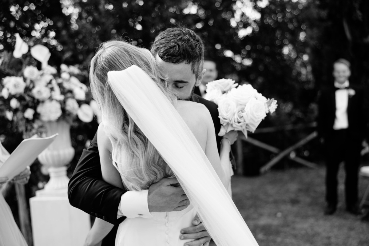 Wedding Borgo Sant Ambrogio Tuscany Italy 51 - A Modern, Romantic Destination Wedding at Borgo Sant Ambrogio in Tuscany Bride and groom embracing during their ceremony. Groom nestling into the bride's neck.