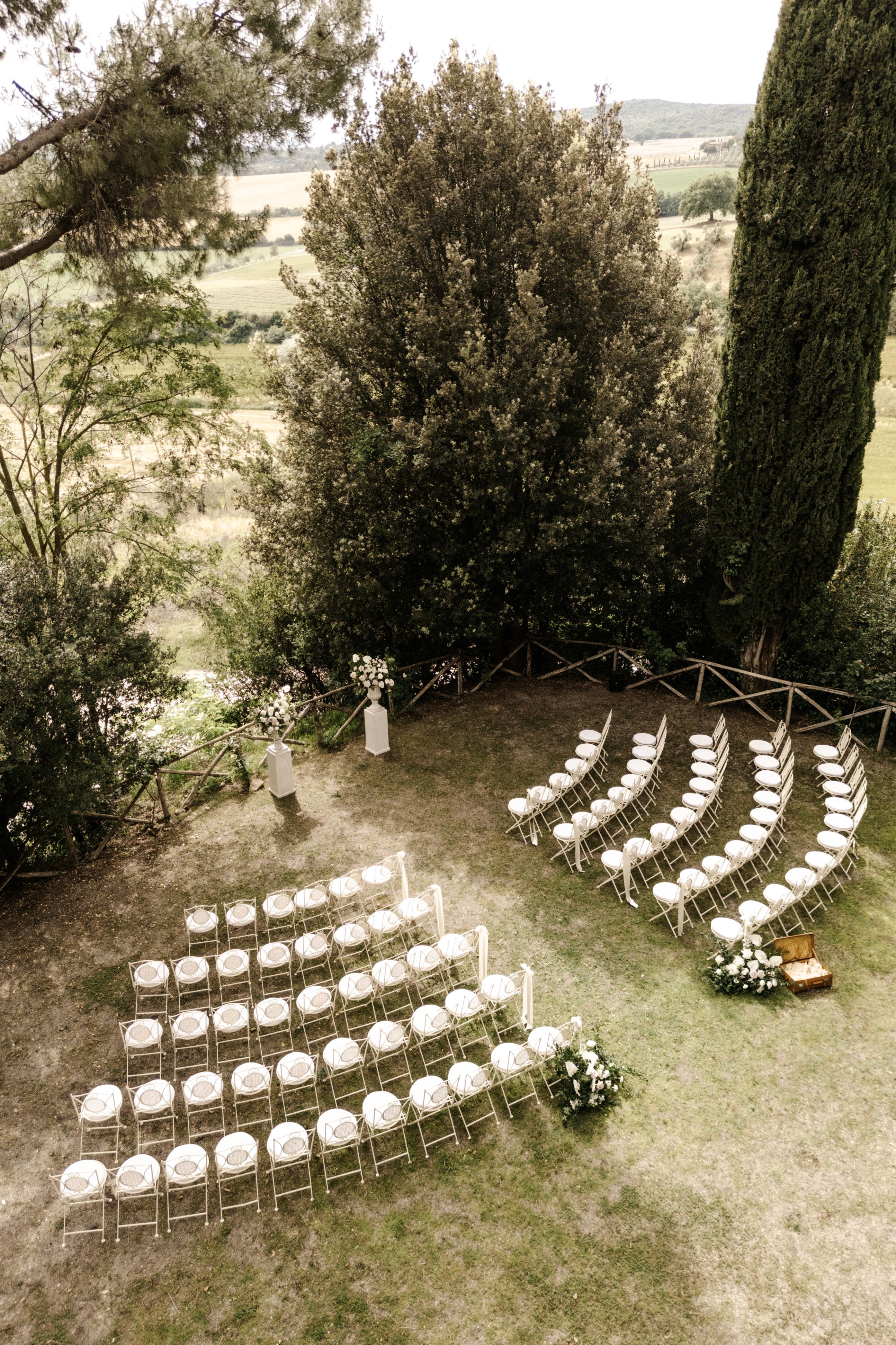 rachelluke 254 - A Modern, Romantic Destination Wedding at Borgo Sant Ambrogio in Tuscany Curved rows of seats for an outdoor wedding in the gardens of Borgo Sant Ambrogio in Tuscany, Italy.