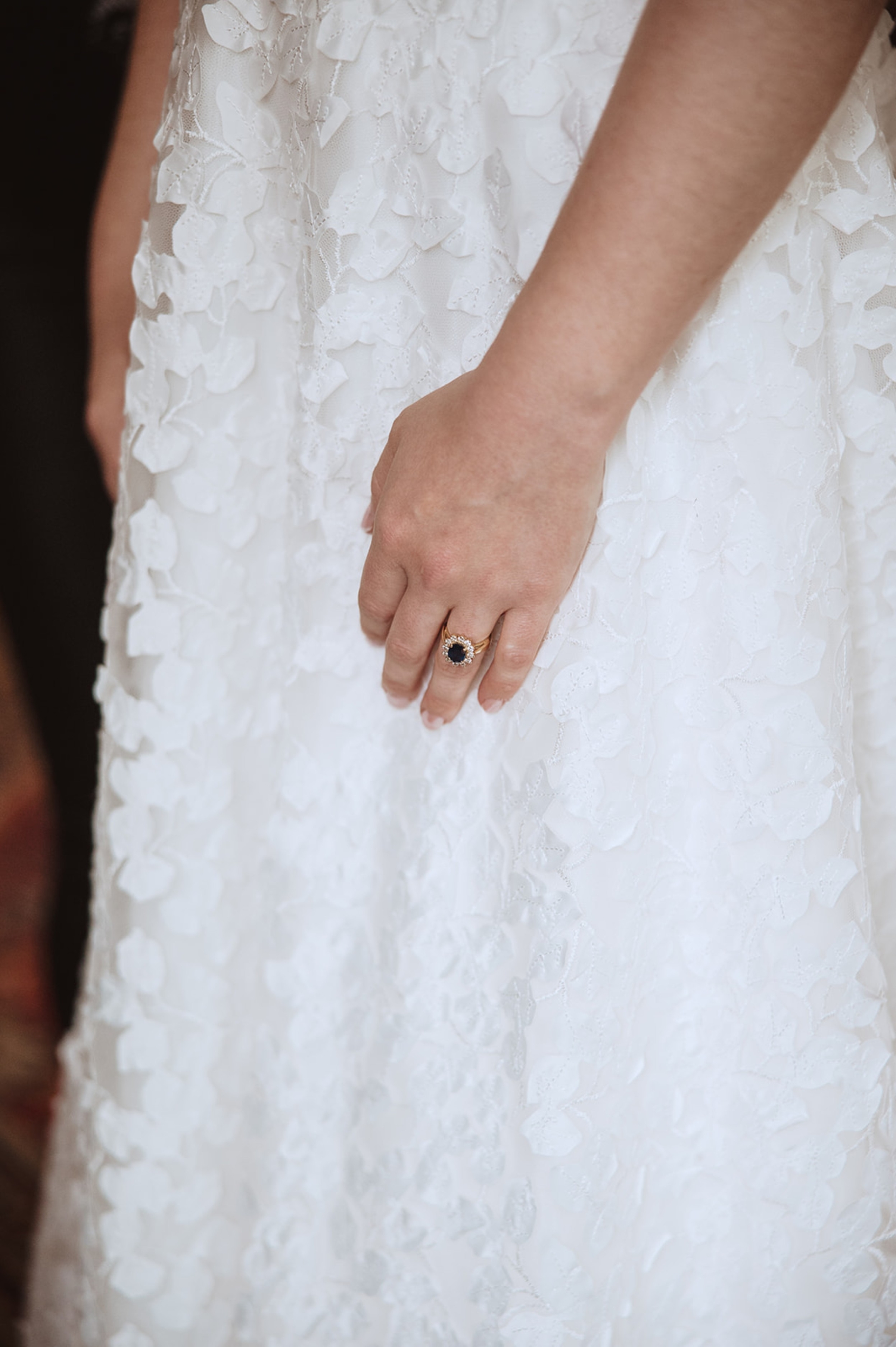 Bore Place Wedding Sassi Holford bride 22 - Hatty & Ben’s Nancy Meyers Inspired Black Tie Wedding at Bore Place, Kent Close up of a bride wearing the Ophelia dress by Sassi Holford. She wears a sapphire engagement ring.