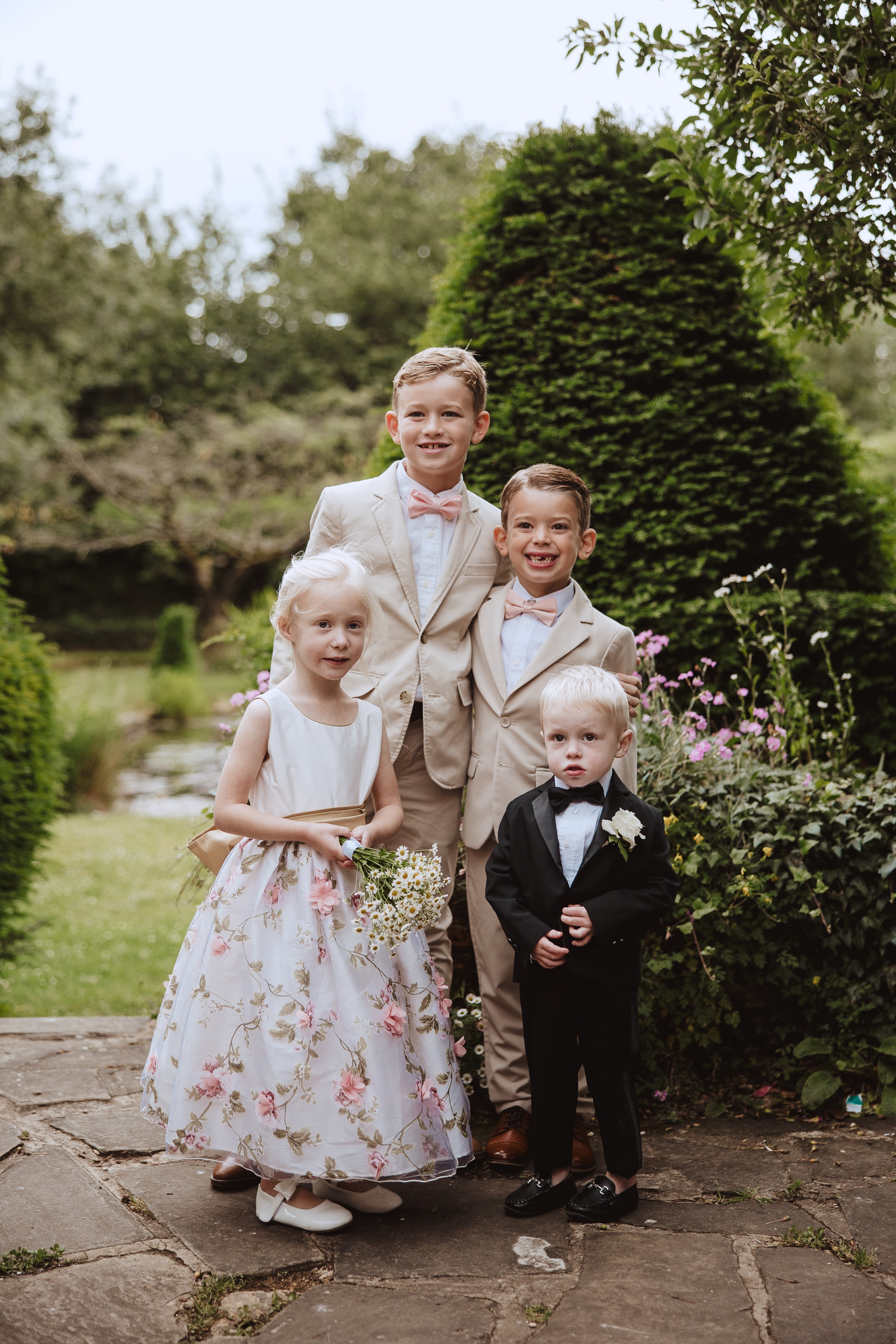 Bore Place Wedding Sassi Holford bride 42 - Hatty & Ben’s Nancy Meyers Inspired Black Tie Wedding at Bore Place, Kent Page boys in pale suits and pink bow ties, and a childs tuxedo. Flowergirl in Nikki Macfarlane.