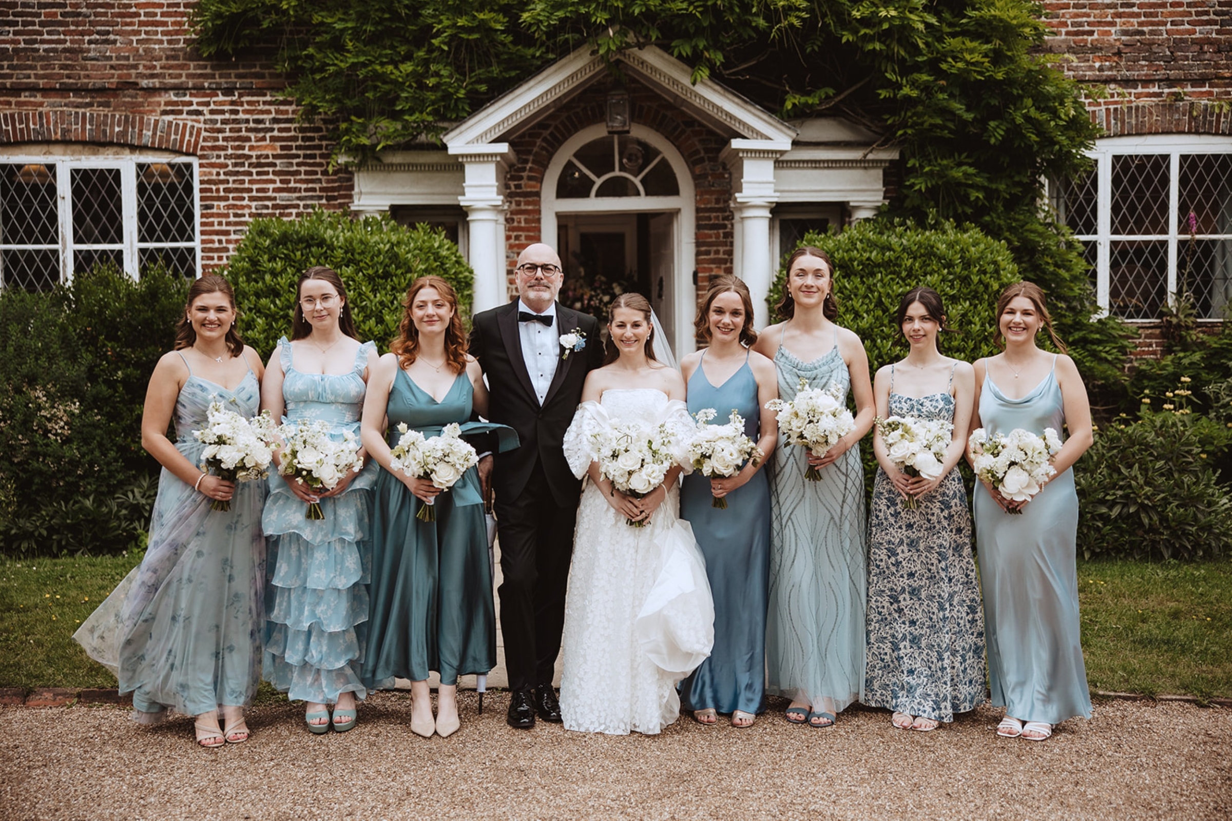 Bore Place Wedding Sassi Holford bride 55 - Hatty & Ben’s Nancy Meyers Inspired Black Tie Wedding at Bore Place, Kent Sassi Holford bride standing with her bridesmaids in pale blue dresses by Rewritten and Maids to Measure outside Bore Place in Kent.