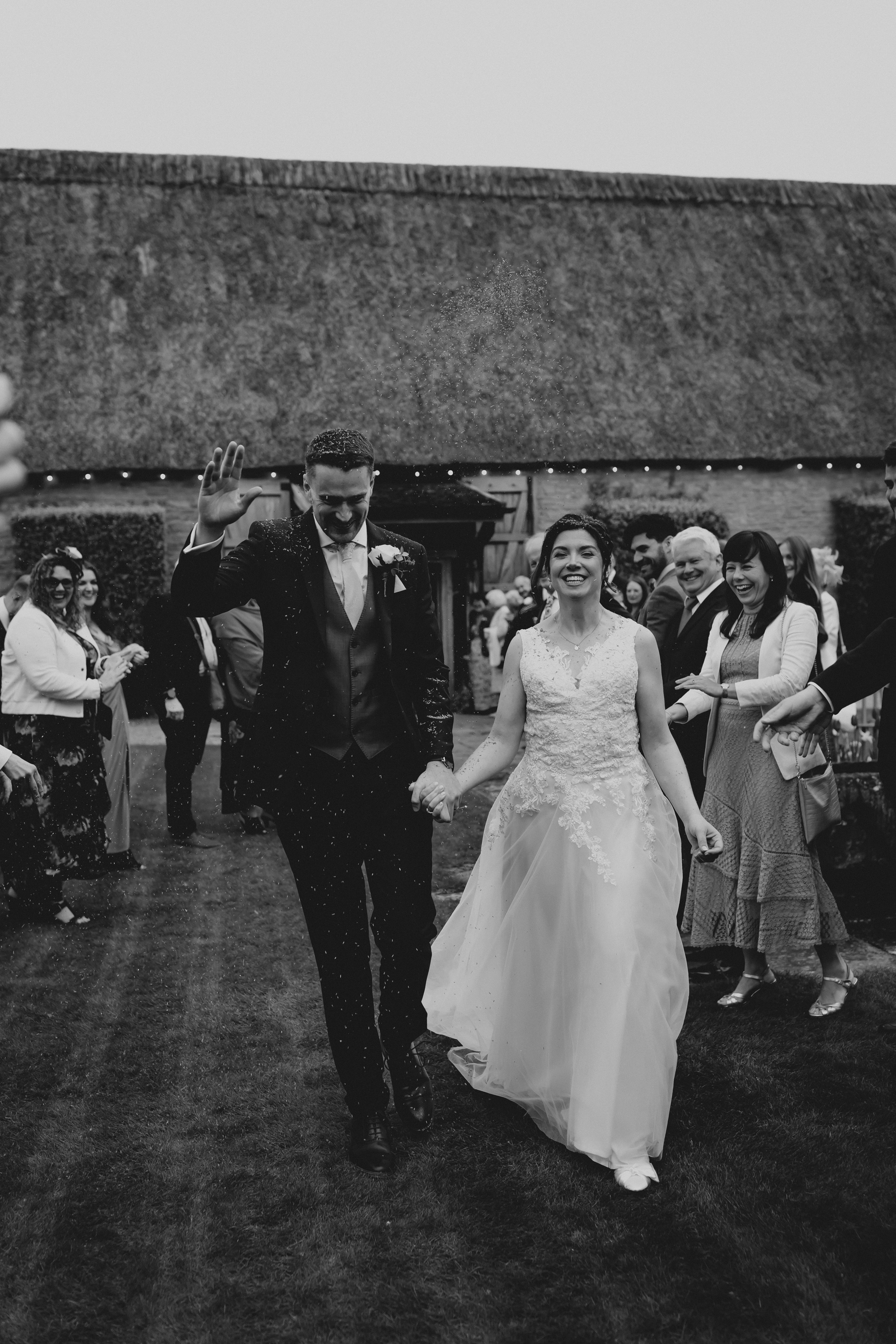 Bride and groom exiting their wedding ceremony at Tythe, an Oxfordshire barn wedding venue. 