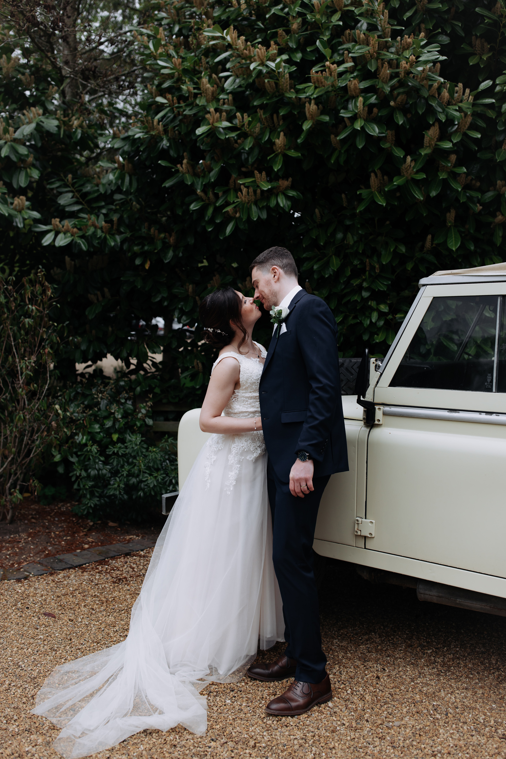 Bride and groom embracing in the gardens at Tythe, an Oxfordshire barn wedding venue. 