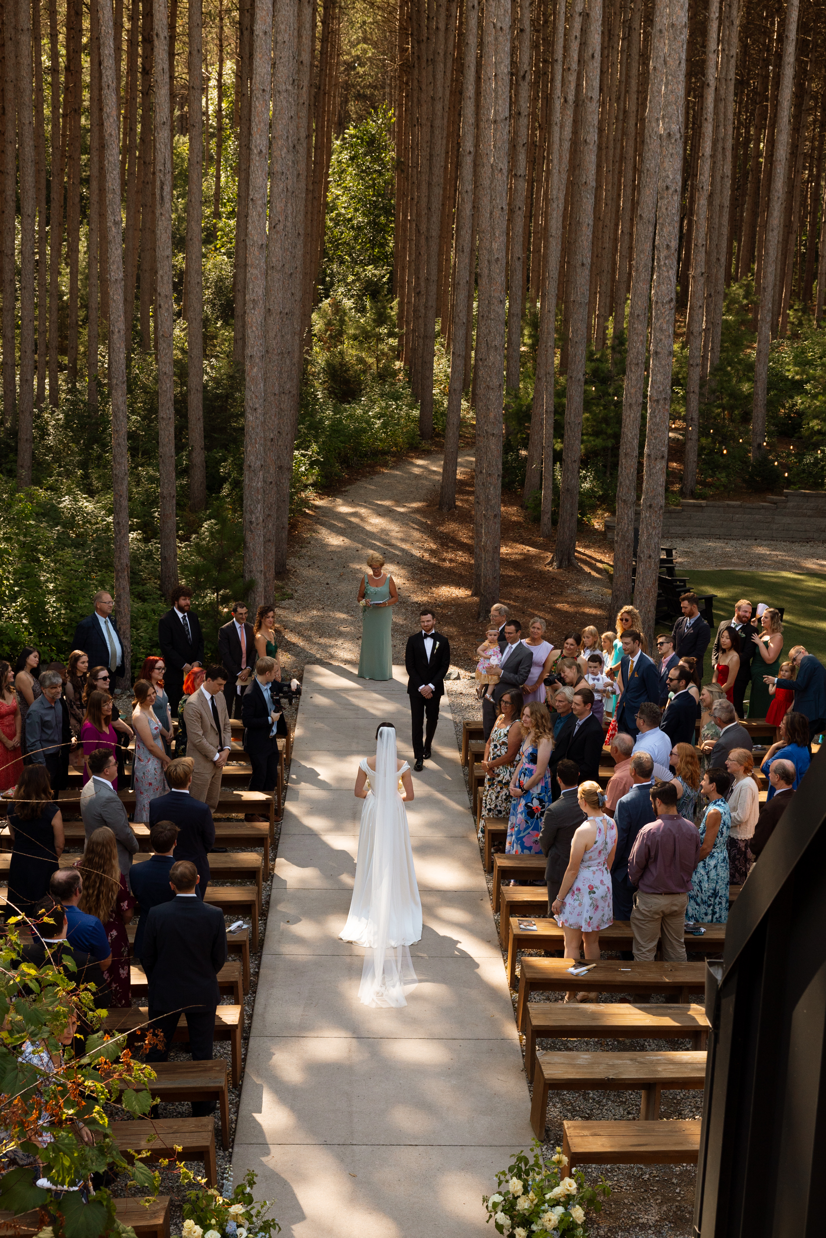 Birdseye view of bride walking down the aisle at Pinewood Weddings & Events in MA, USA. She wears Vivienne Westwood.