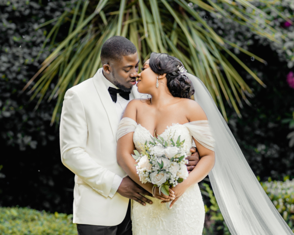 Bride and groom embracing in lush garden setting - romantic Manchester wedding photography by Calini Weddings.