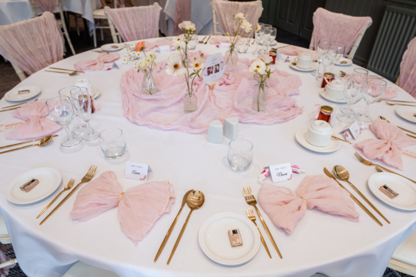 Soft pink and gold wedding table setting with floral accents – elegant reception styling captured by Calini Weddings.