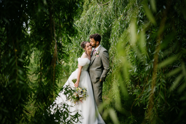 bride and groom by the willow trees
