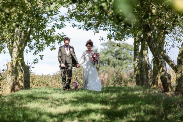 bride and groom walking in the orchard